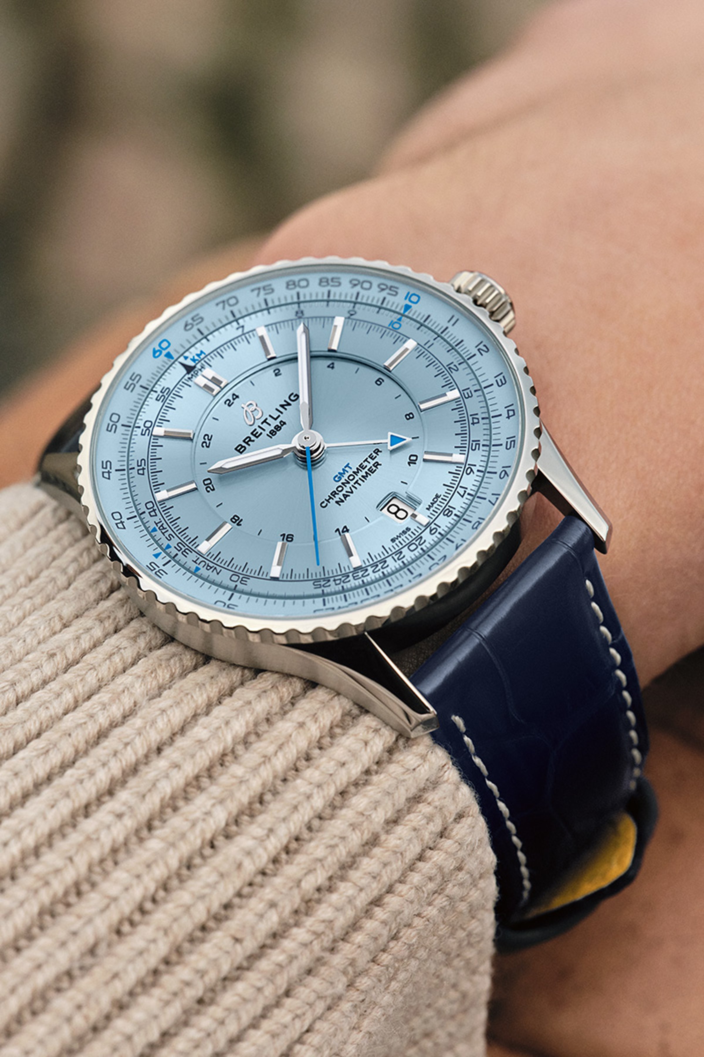 {generated} Breitling Navitimer GMT con esfera azul clara y correa de cuero azul en la muñeca, mostrando sus detalles precisos