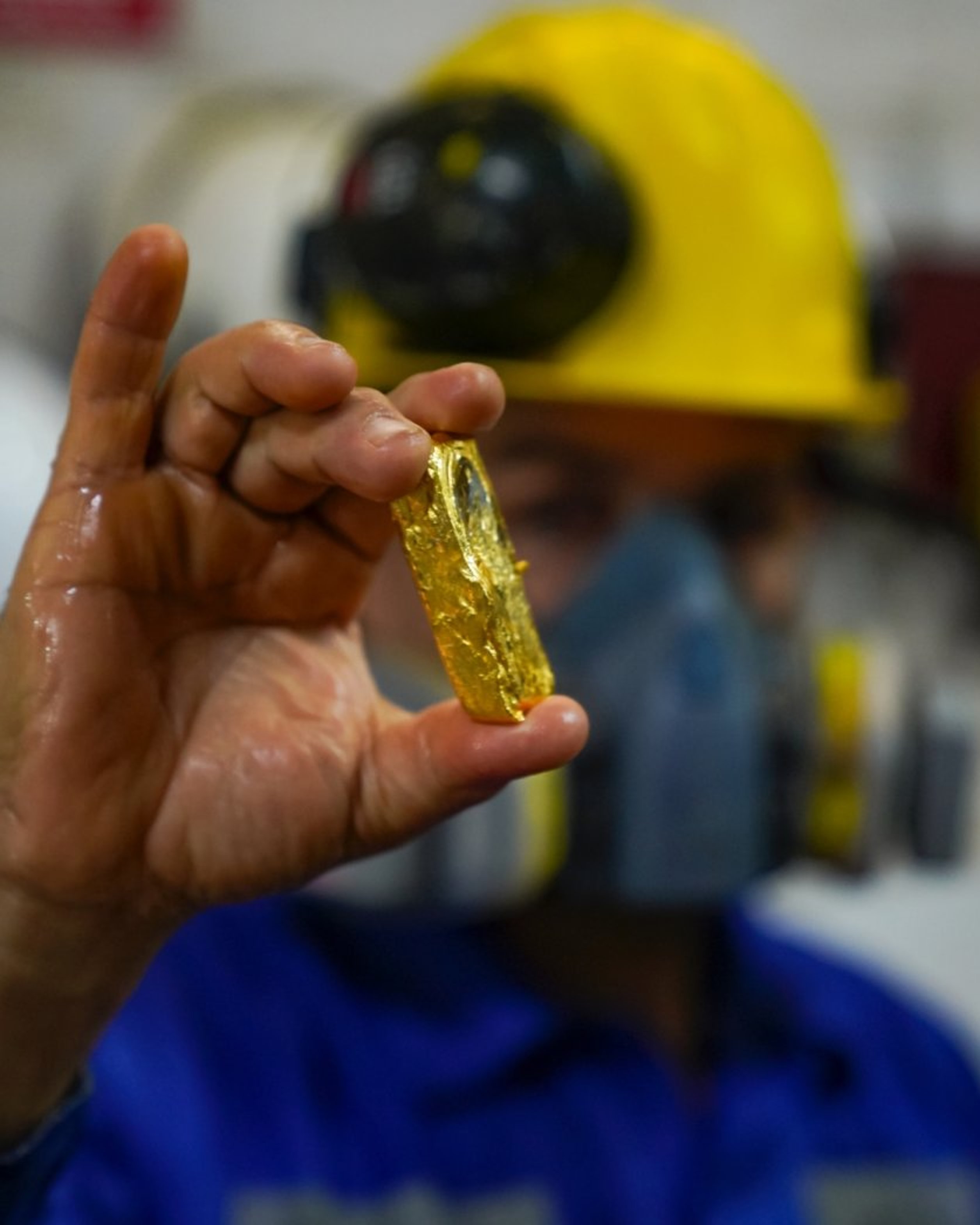 {generated} Un travailleur tient un petit fragment d’or responsable, illustrant l’engagement de Breitling envers des matériaux durables