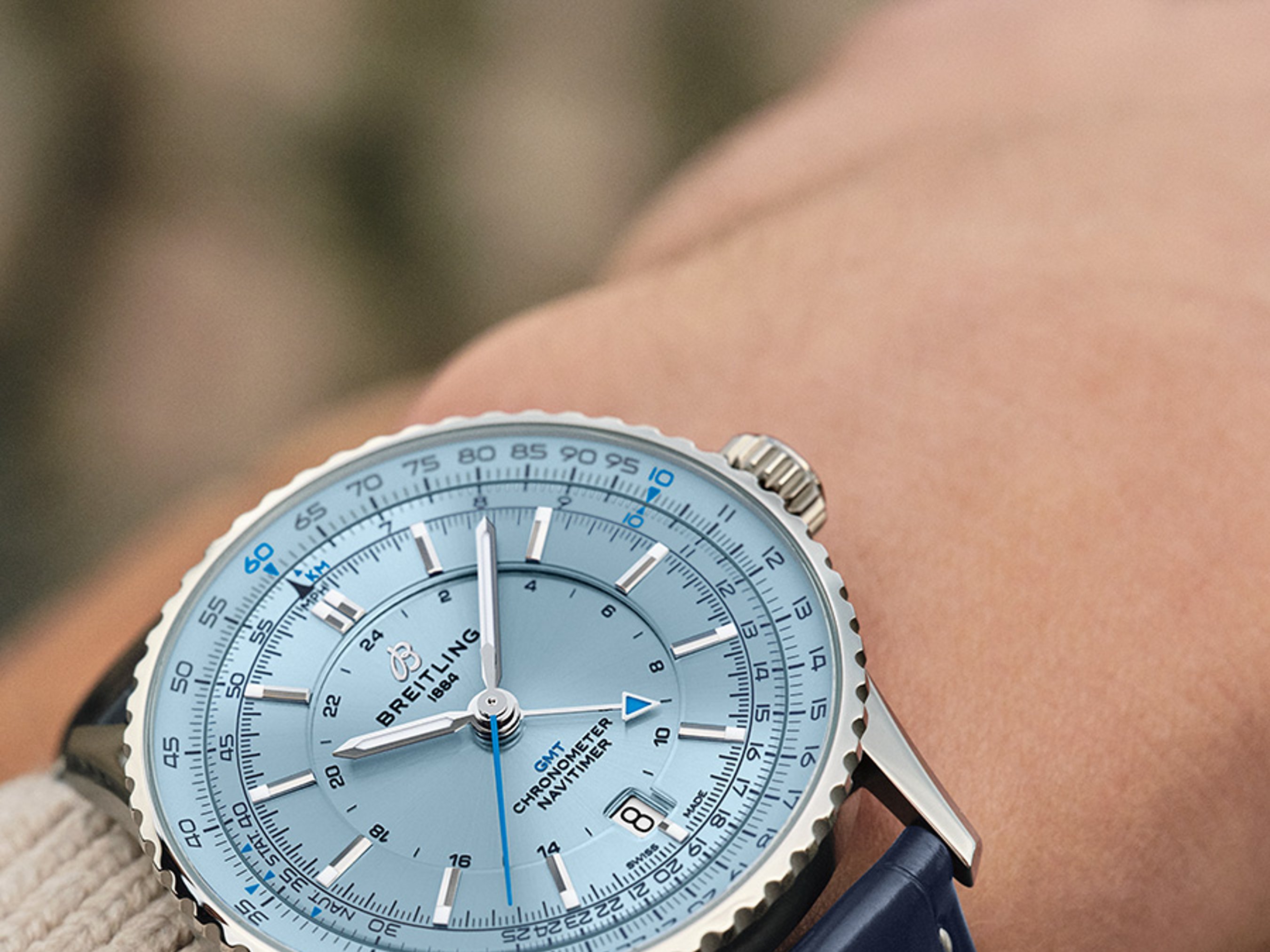 {generated} Breitling Navitimer GMT con esfera azul clara y correa de cuero azul en la muñeca, mostrando sus detalles precisos