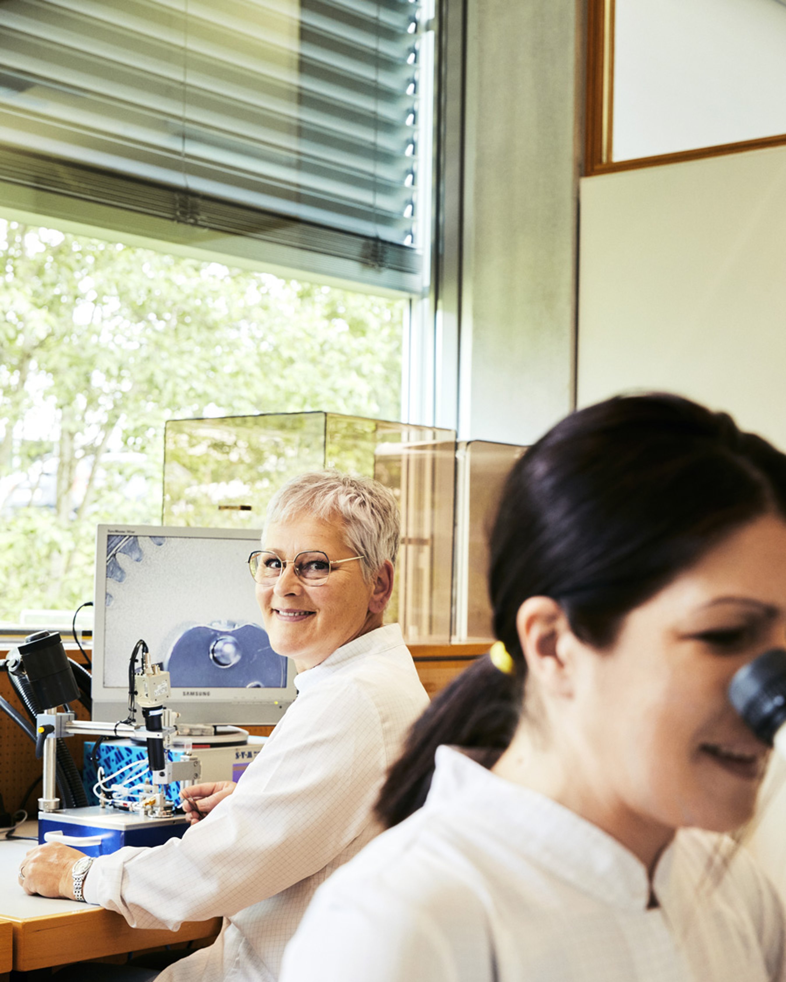 {generated} Des horlogers dans un atelier Breitling lumineux se consacrent à des tâches précises sur postes techniques, reflétant l’équité salariale.