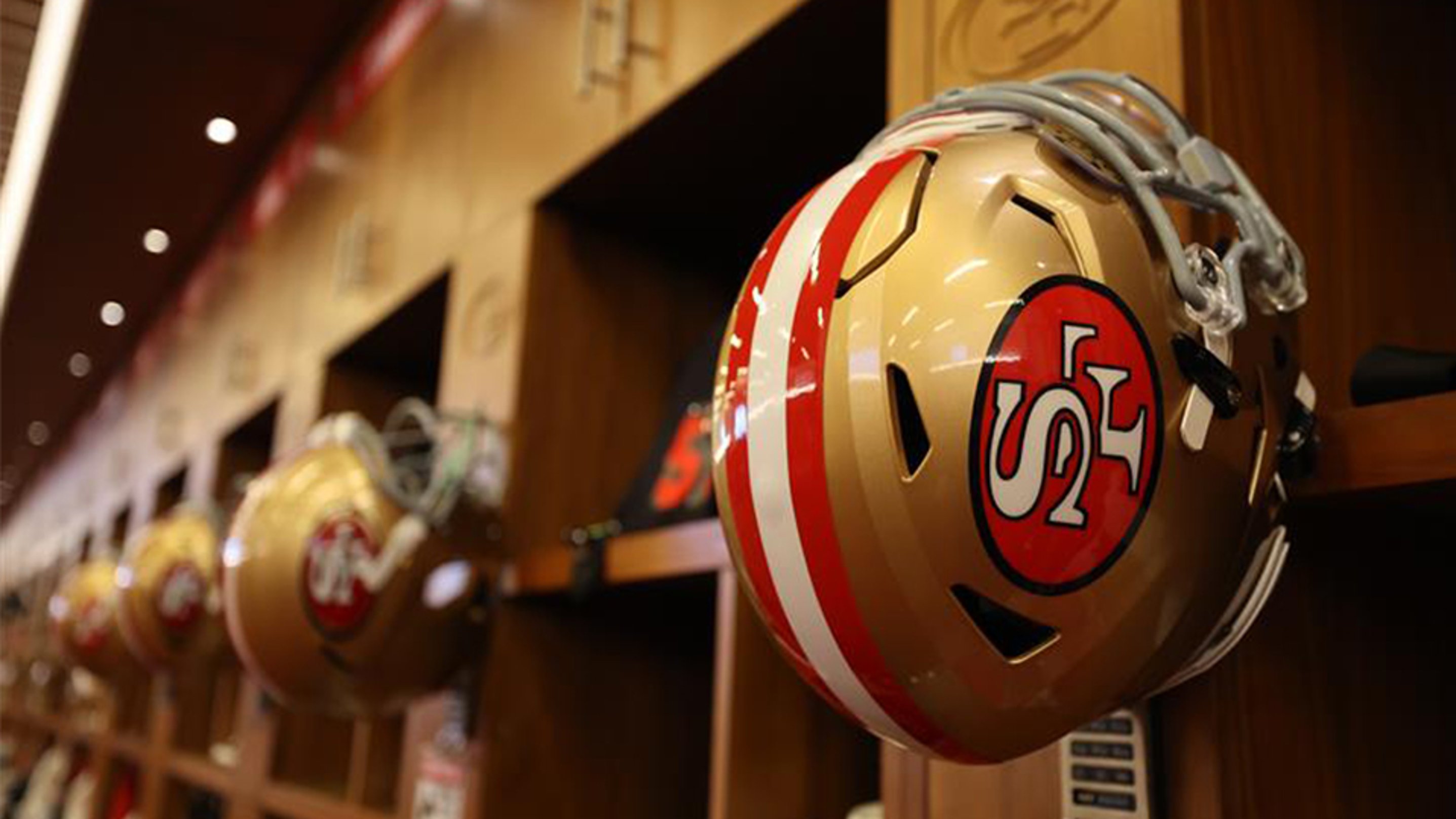 {generated} Gold San Francisco 49ers helmets line wooden lockers, highlighting team gear in a structured athletic locker room.