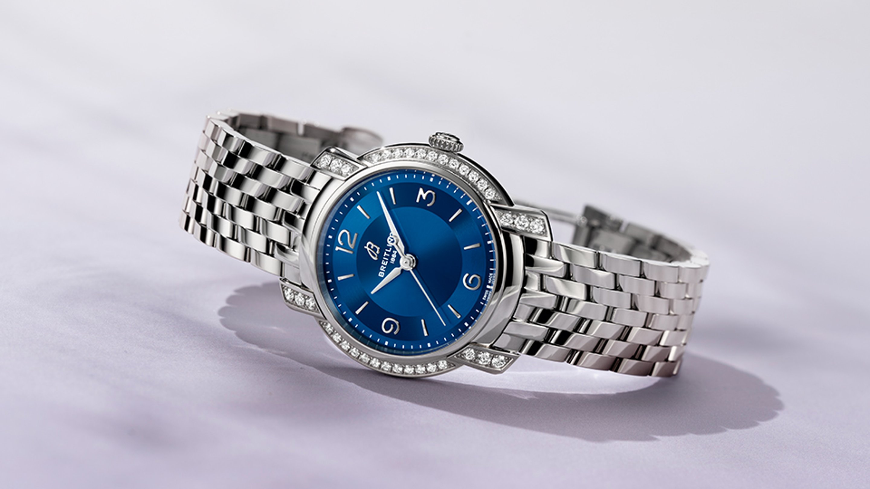 {generated} Reloj Breitling Chronomat con esfera azul y bisel con diamantes sobre una superficie clara que realza su elegancia