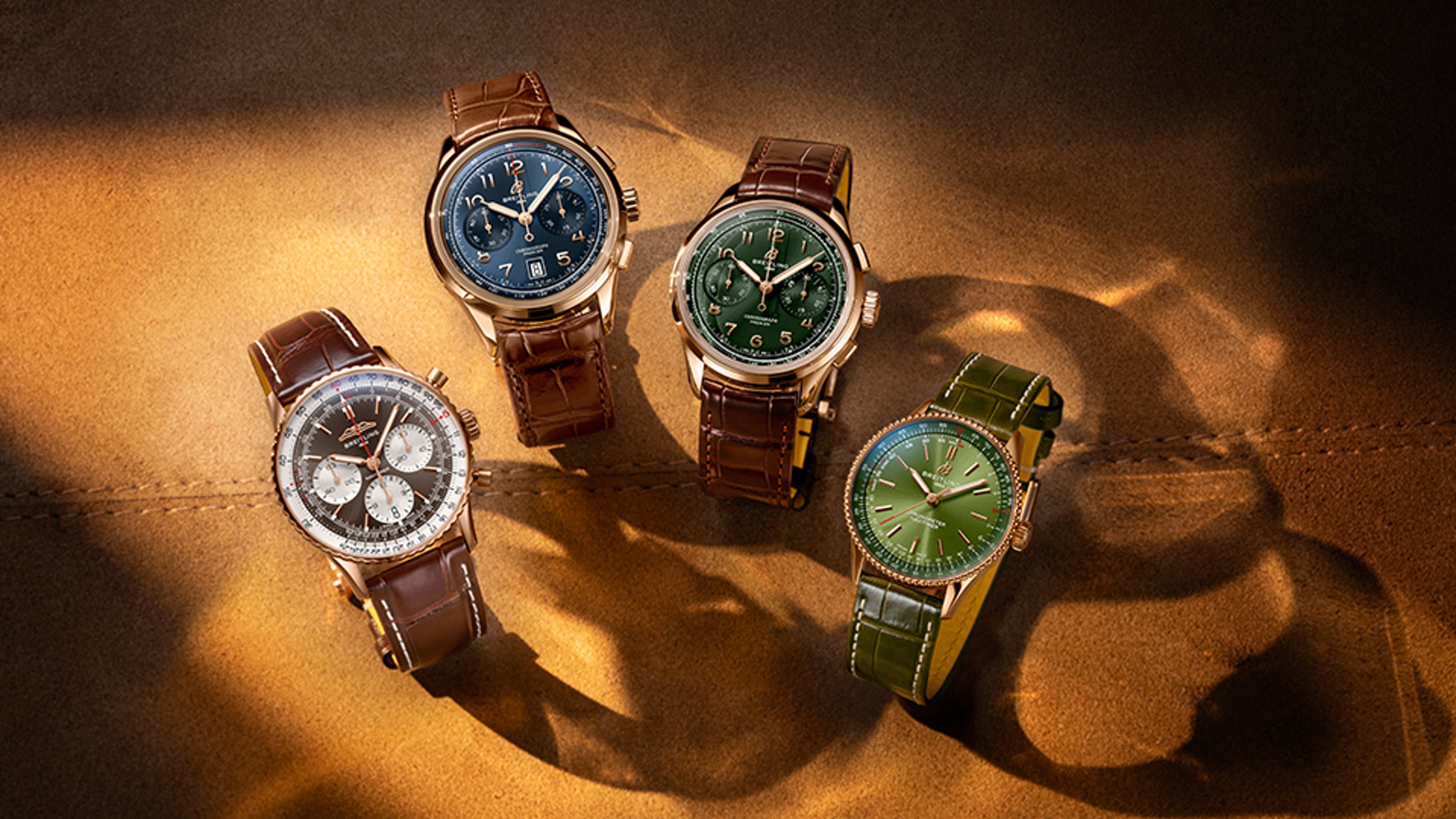 {generated} Relojes Breitling Gold Capsule sobre cuero cálido con esferas azul, verde y plata en elegantes diseños dorados.