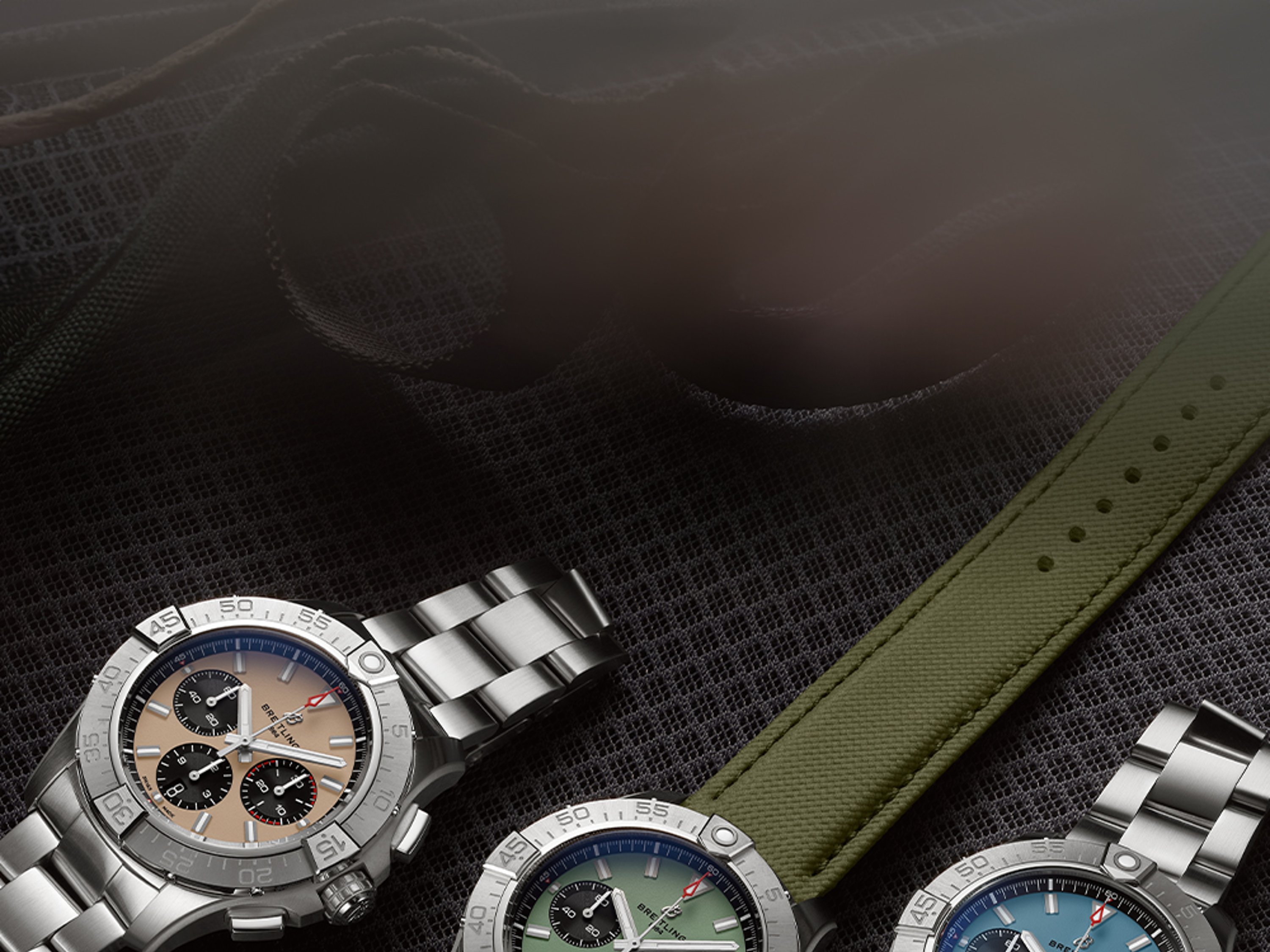 Three Avengers with different colored dials rest on black seats.