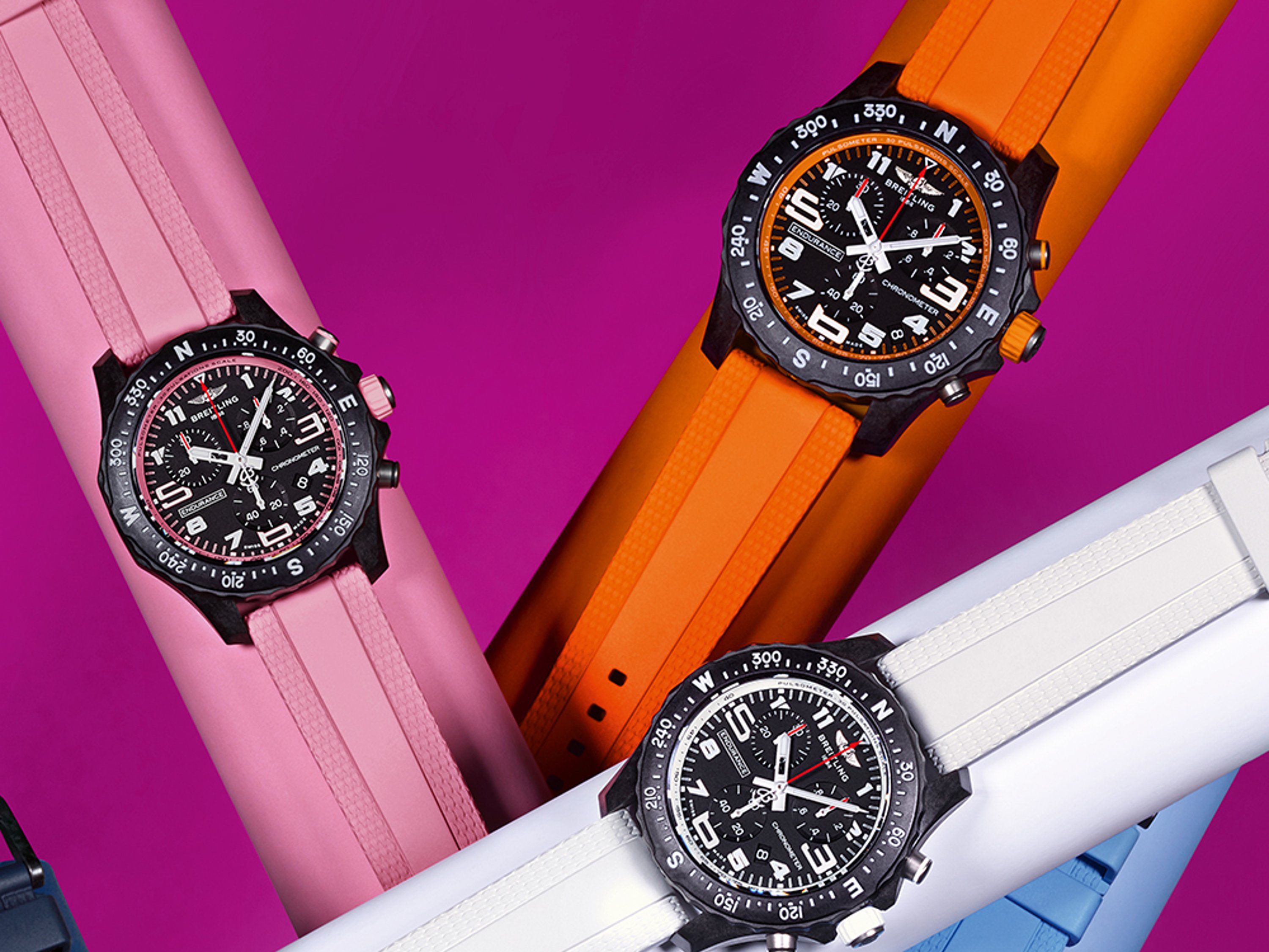 Six Endurance Pro watches in the colors pink, orange, white, light blue, dark blue and purple against a purple background.