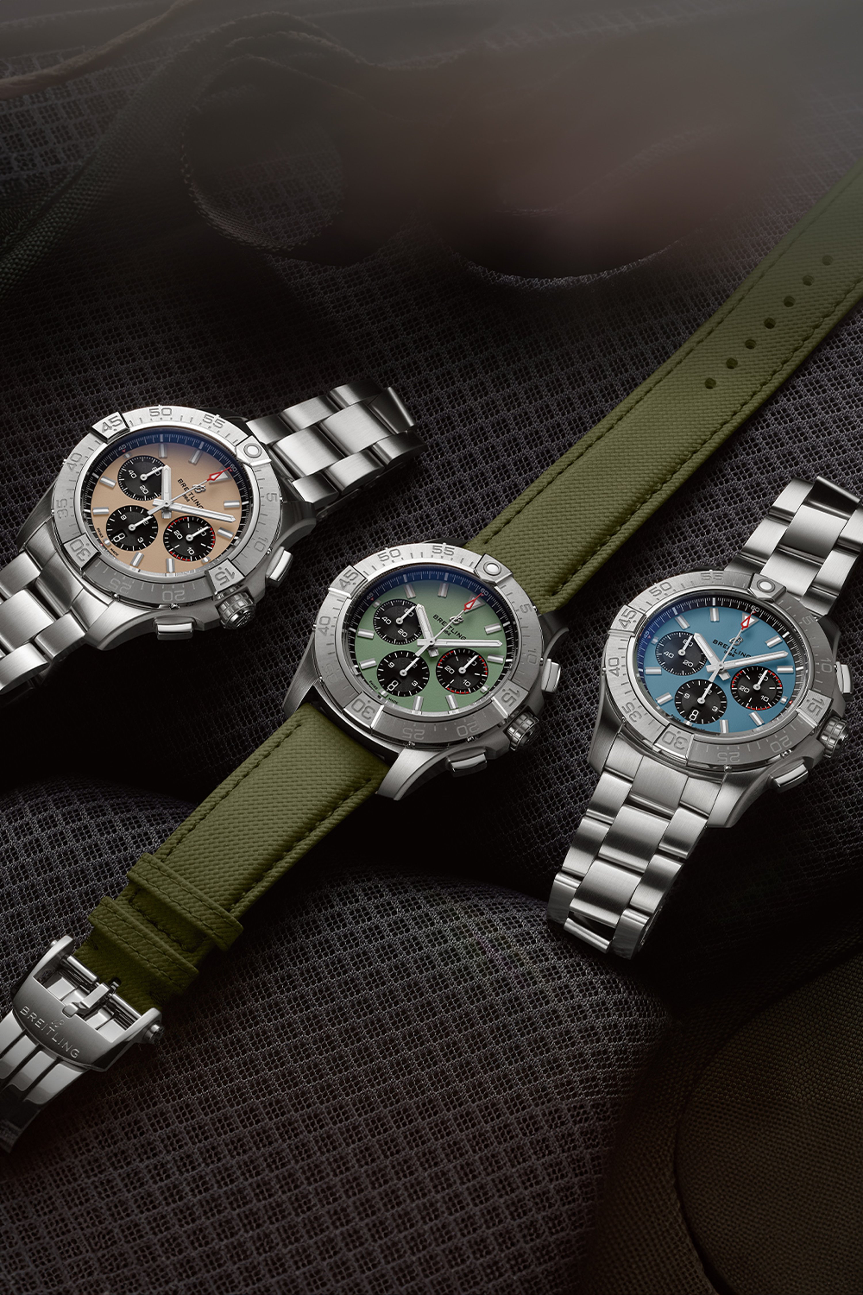 Three Avengers with different colored dials rest on black seats.