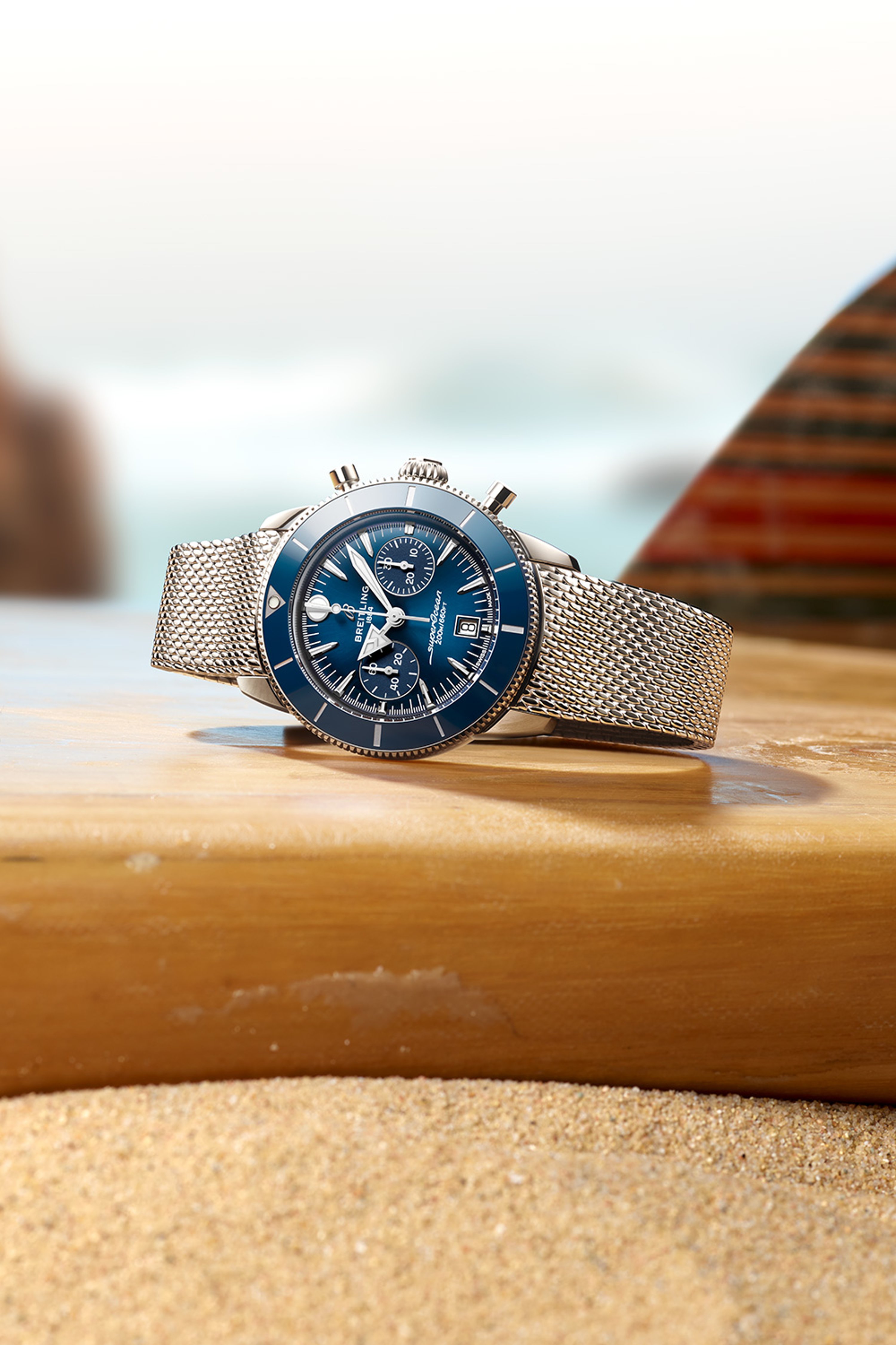 A dark blue Superocean Heritage lies on a table with a magazine and a white rope.