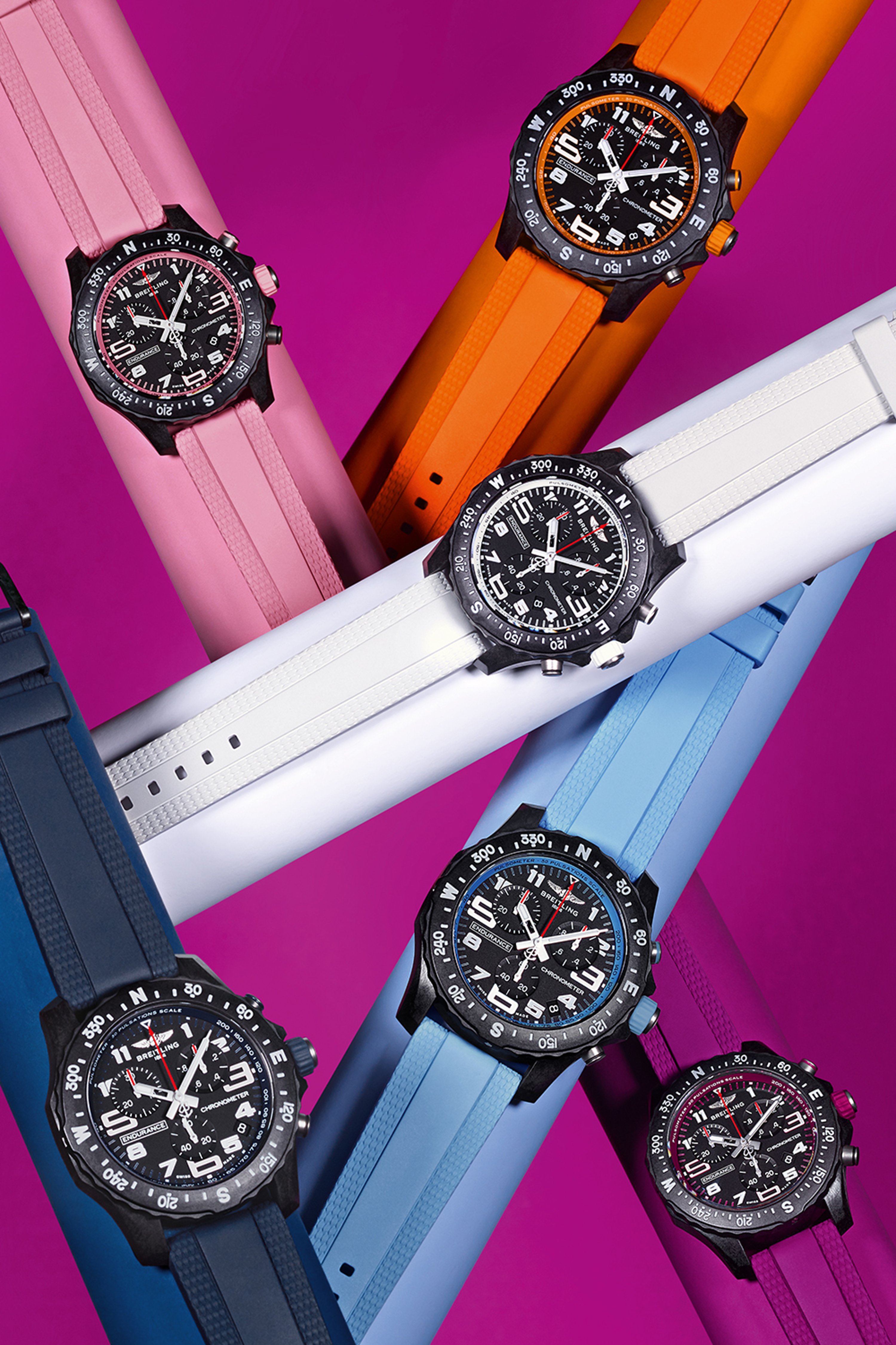 Six Endurance Pro watches in the colors pink, orange, white, light blue, dark blue and purple against a purple background.