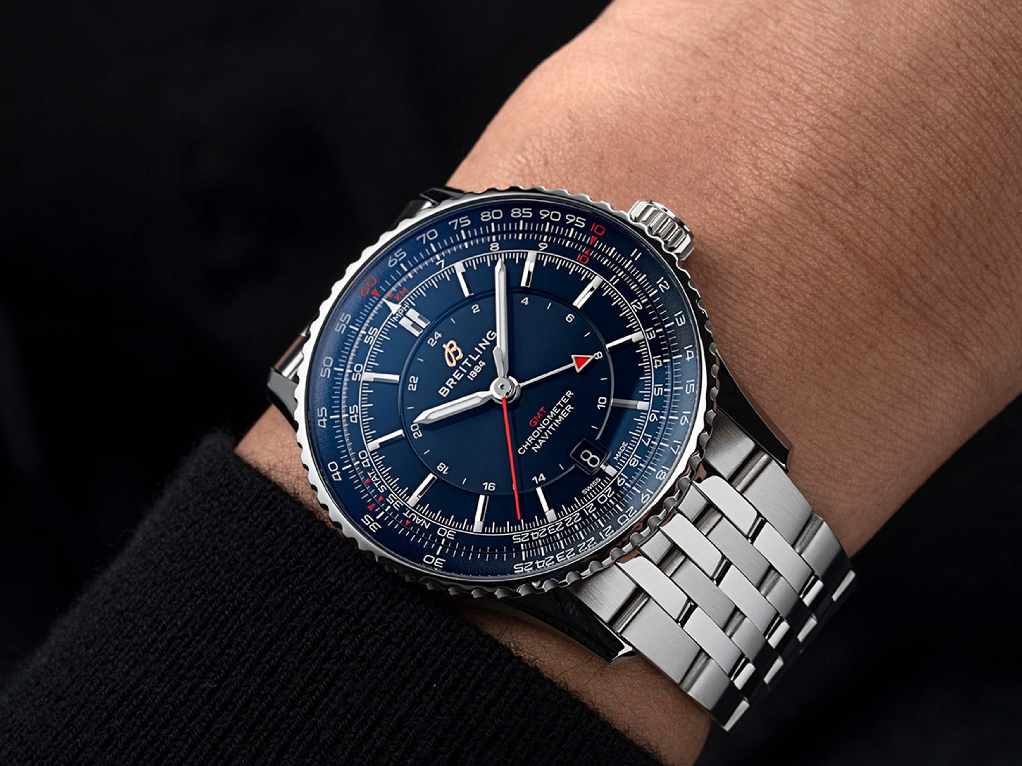 {generated} 腕元のBreitling Navitimer GMT41 Samuraiが青い文字盤と赤いGMT針、ステンレススチールブレスを際立たせる構図。