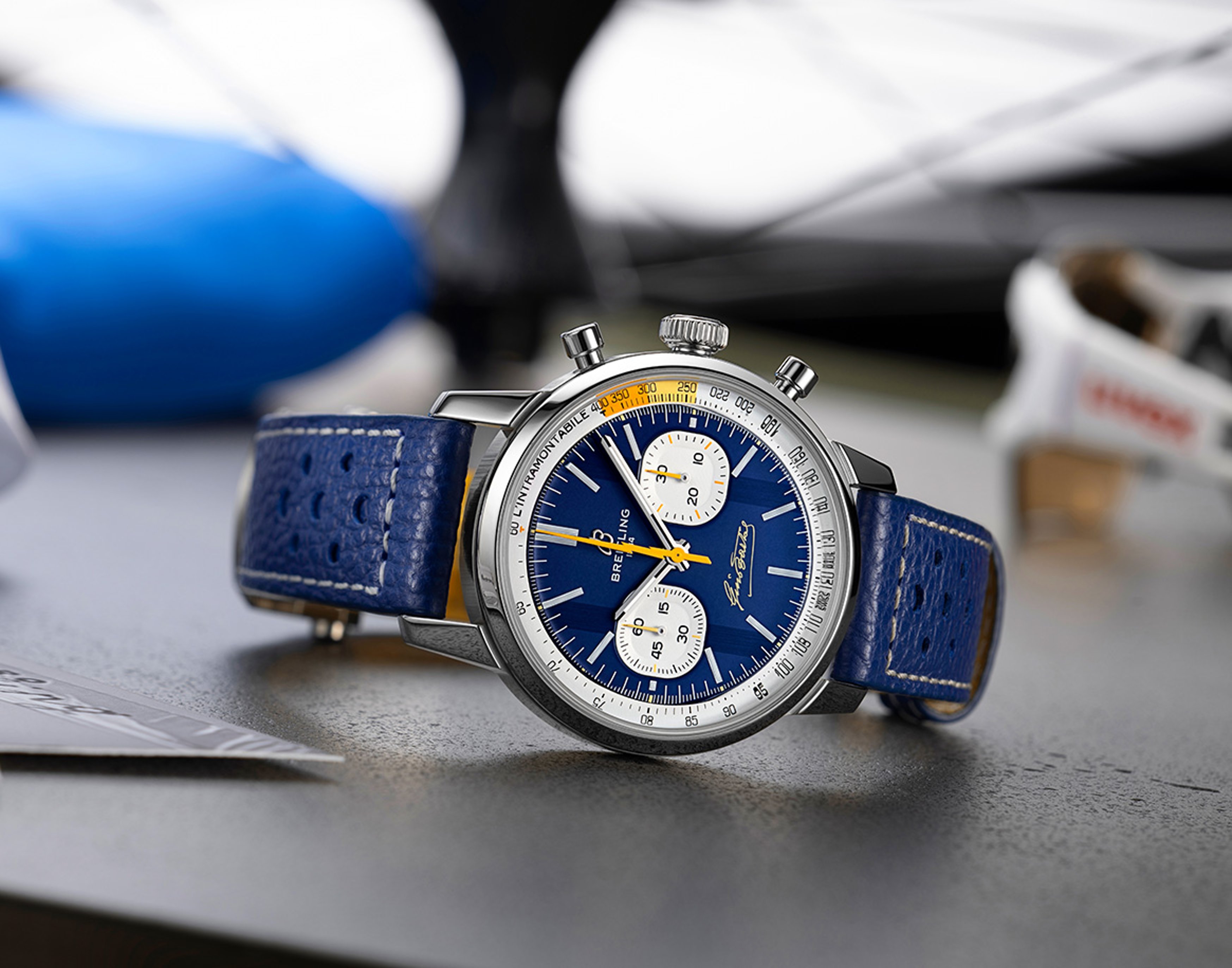 {generated} Breitling Bartali chronograph with blue dial and leather strap displayed on a desk with subtle cycling elements nearby