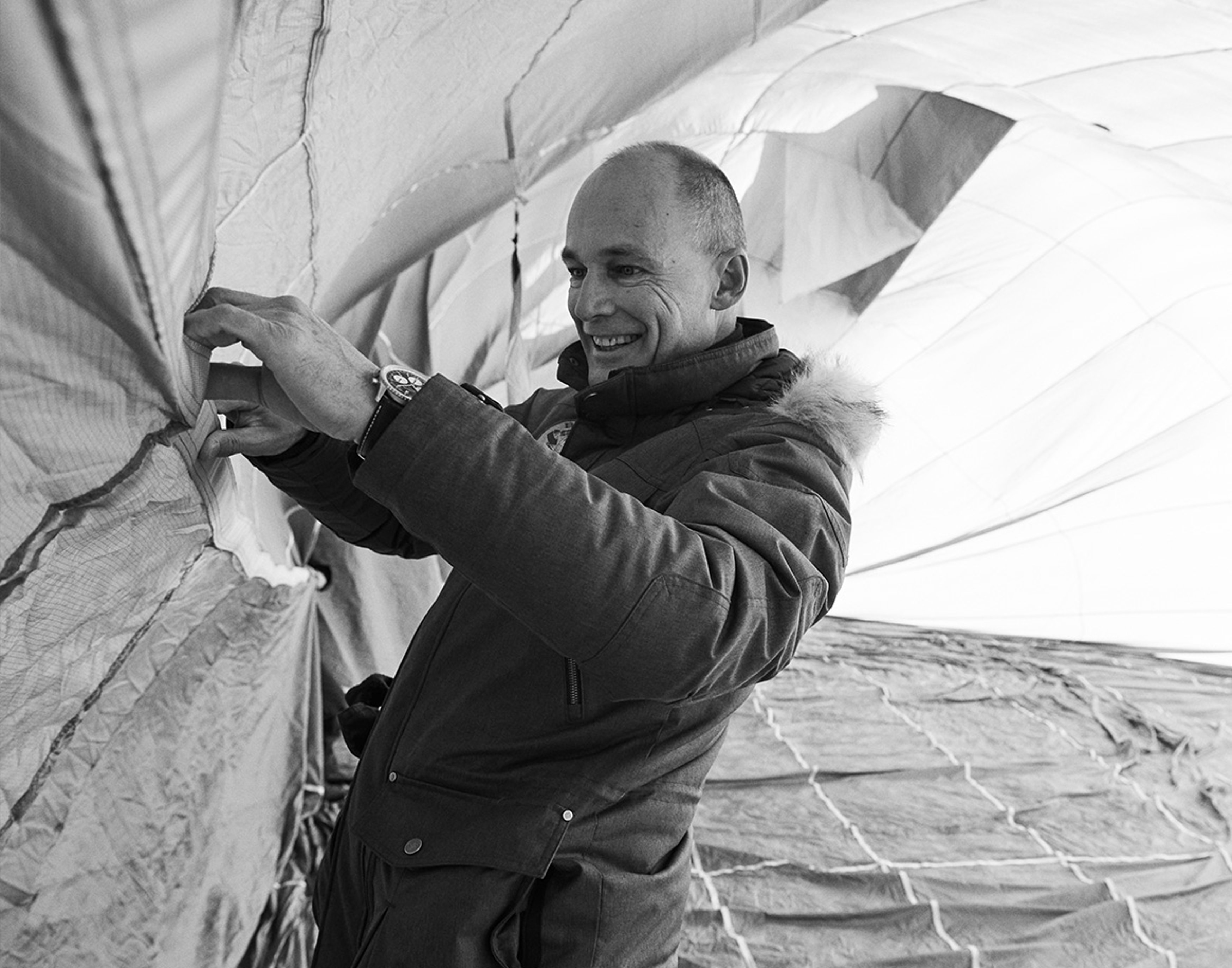 {generated} An ambassador adjusts balloon fabric while wearing a Breitling watch, expressing precision and an exploration spirit.