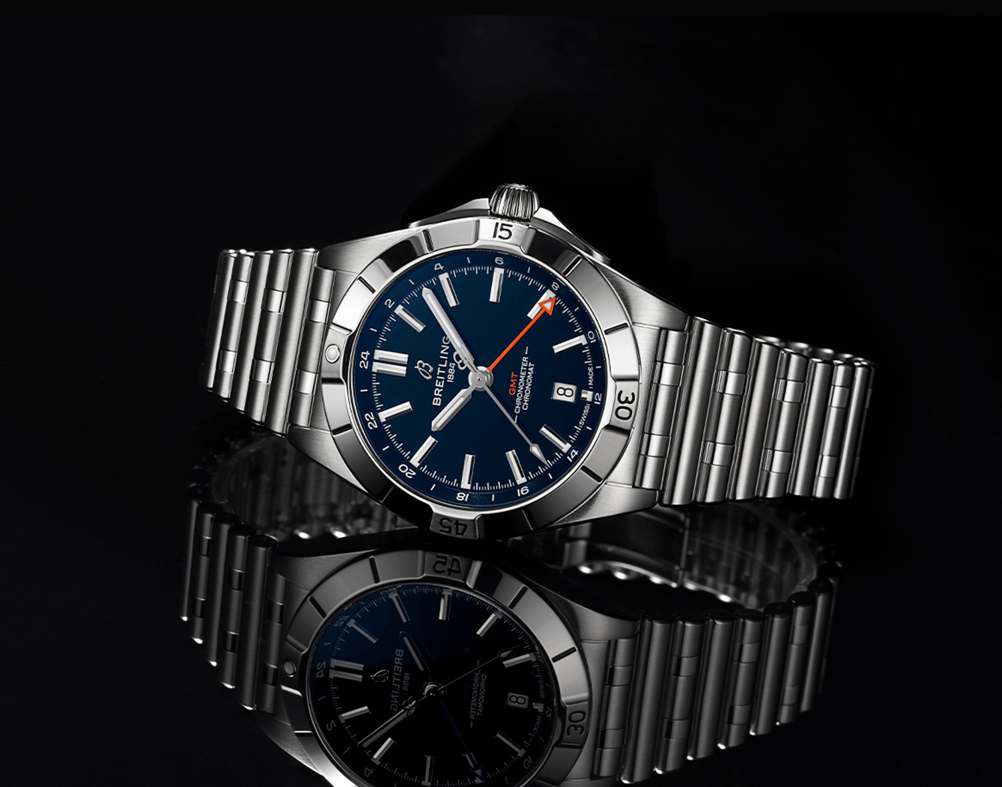 {generated} Breitling Chronomat GMT in blue with steel bracelet shown against a dark reflective surface for the Chicago Bears collection