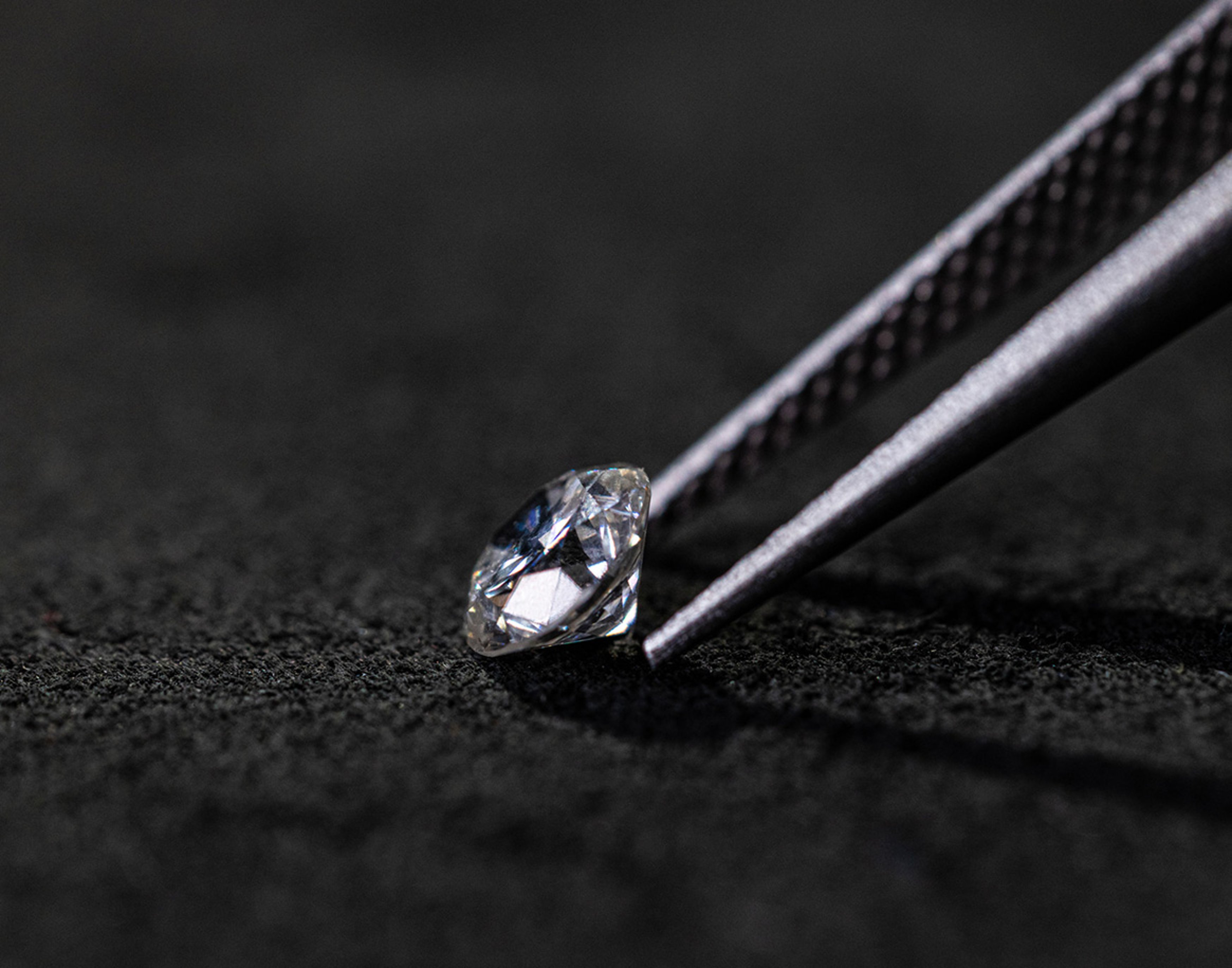 {generated} A polished diamond held by precision tweezers on dark fabric, showcasing the refined materials featured in Breitling craftsmanship