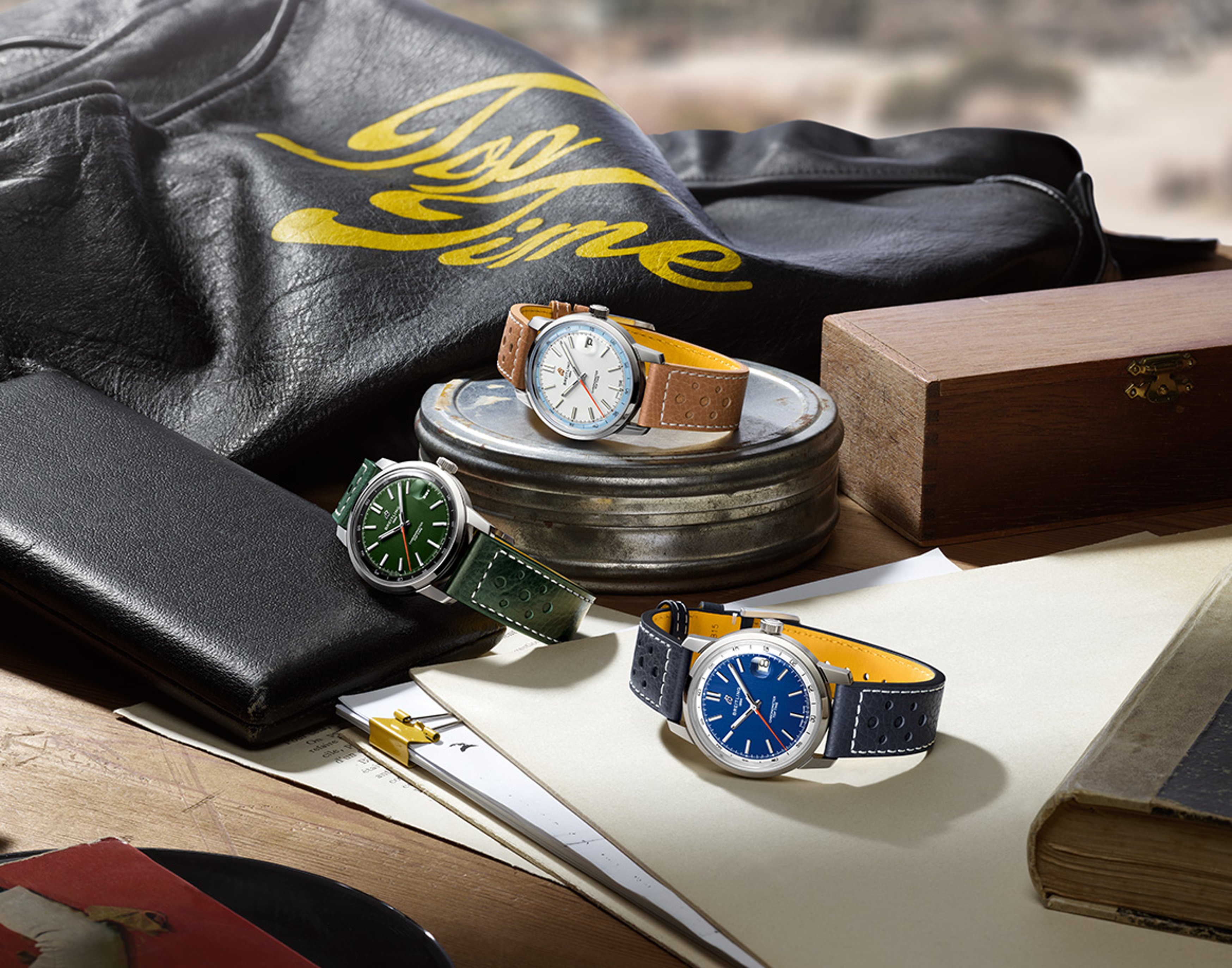{generated} Breitling Top Time watches with green, white and blue dials set on a desk among vintage items for an elegant look