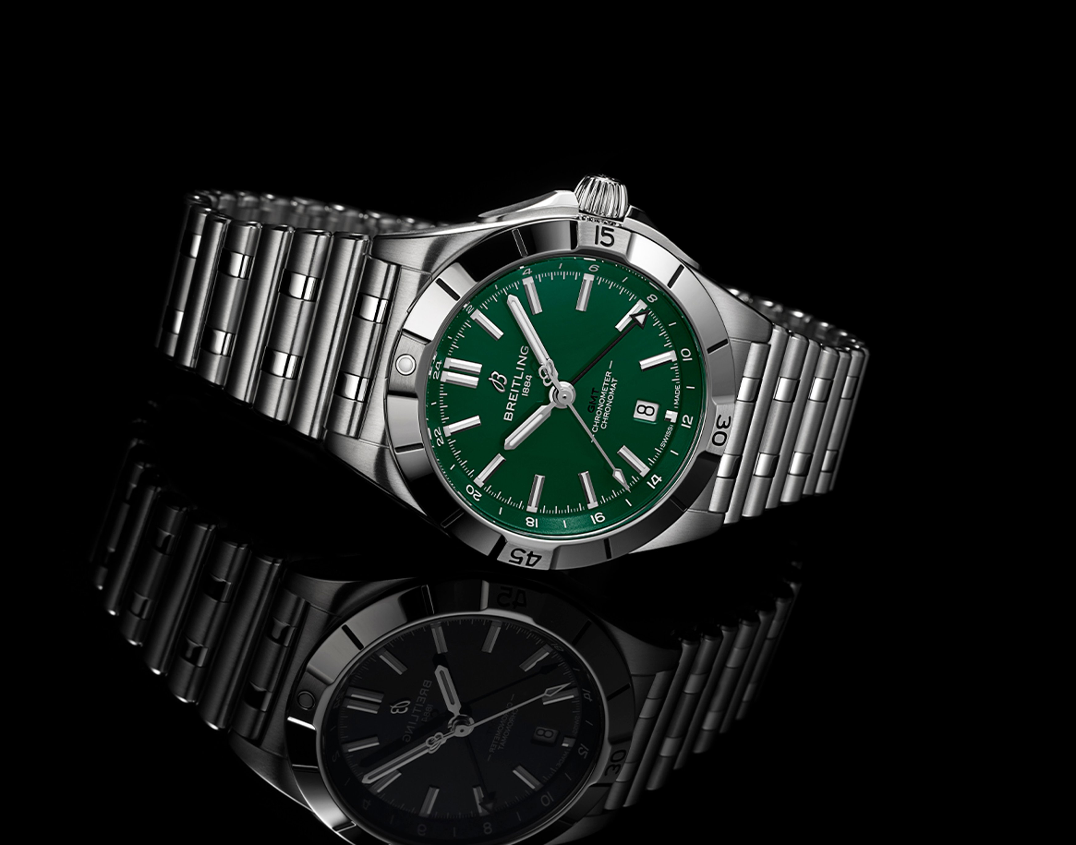 {generated} Breitling Chronomat with green Jets-inspired dial and steel bracelet shown on black surface with refined detail