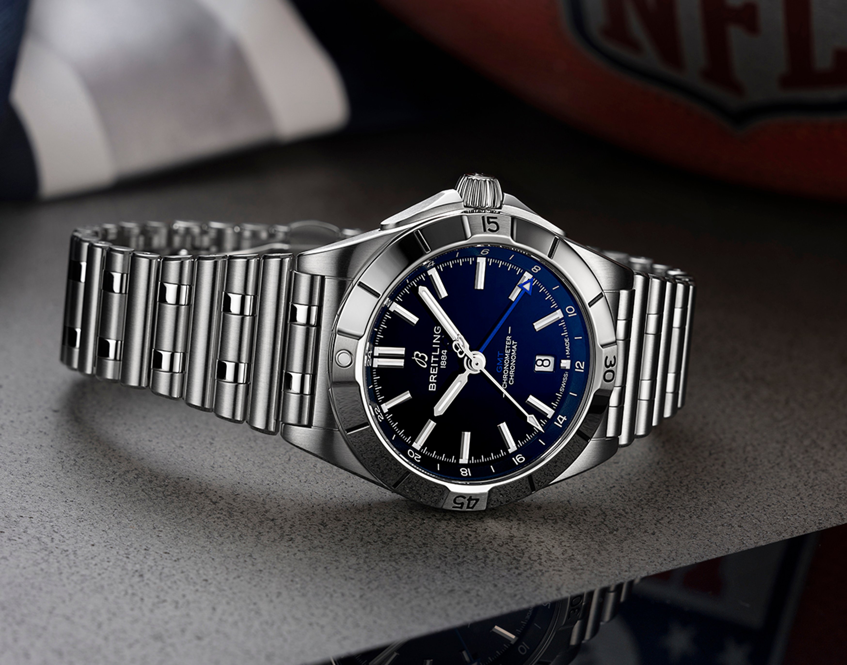 {generated} Breitling Chronomat with blue dial and steel bracelet set beside Dallas Cowboys gear, highlighting sporty refinement