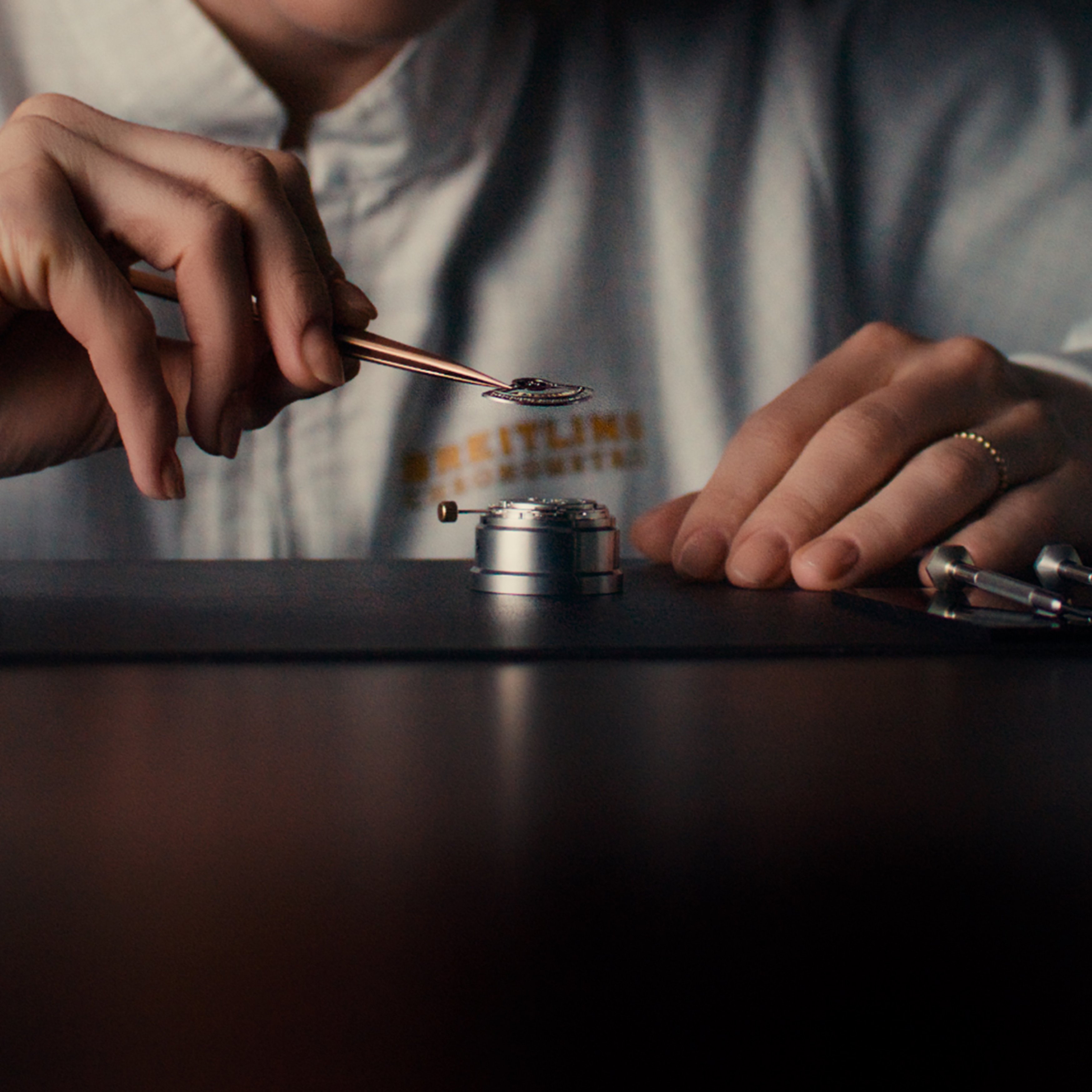 {generated} A watchmaker refines the Breitling Caliber B31 movement with precision tools, highlighting craftsmanship and intricate detail.