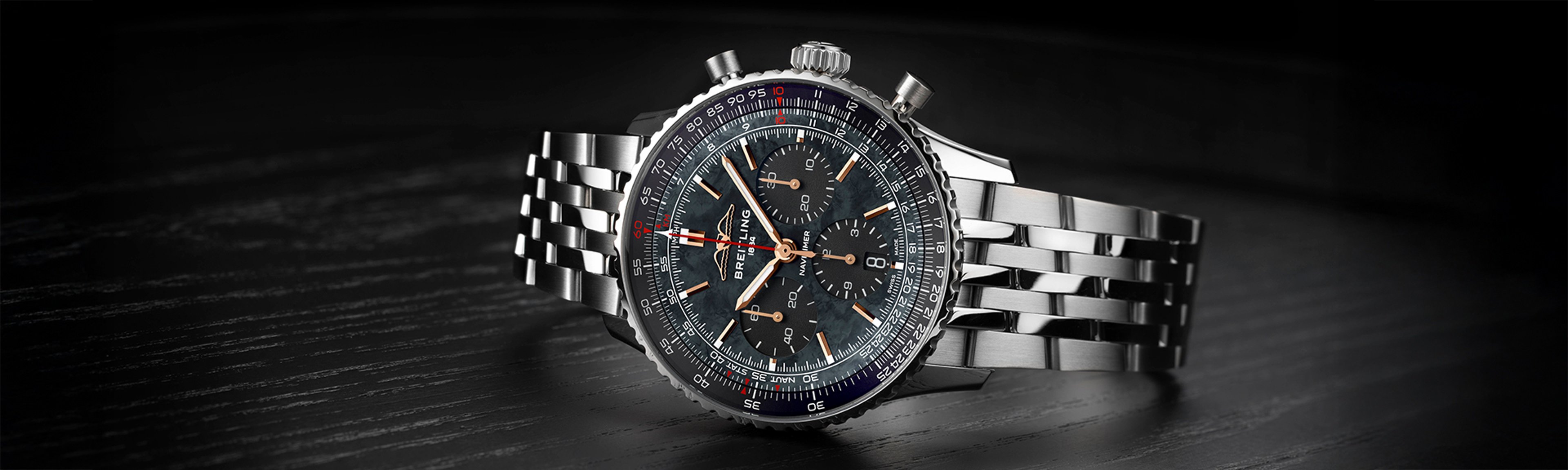 {generated} 暗い面に置かれたBreitling Navitimer B01 Chronograph 43 Japan Editionで、スチールケースとブレスレットが際立つ構図