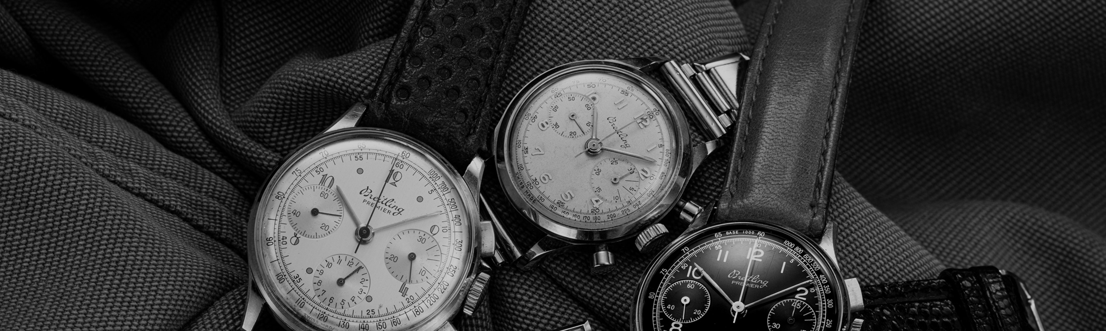 {generated} Vintage Breitling Premier chronographs arranged on textured fabric, highlighting classic dials, cases, and leather straps