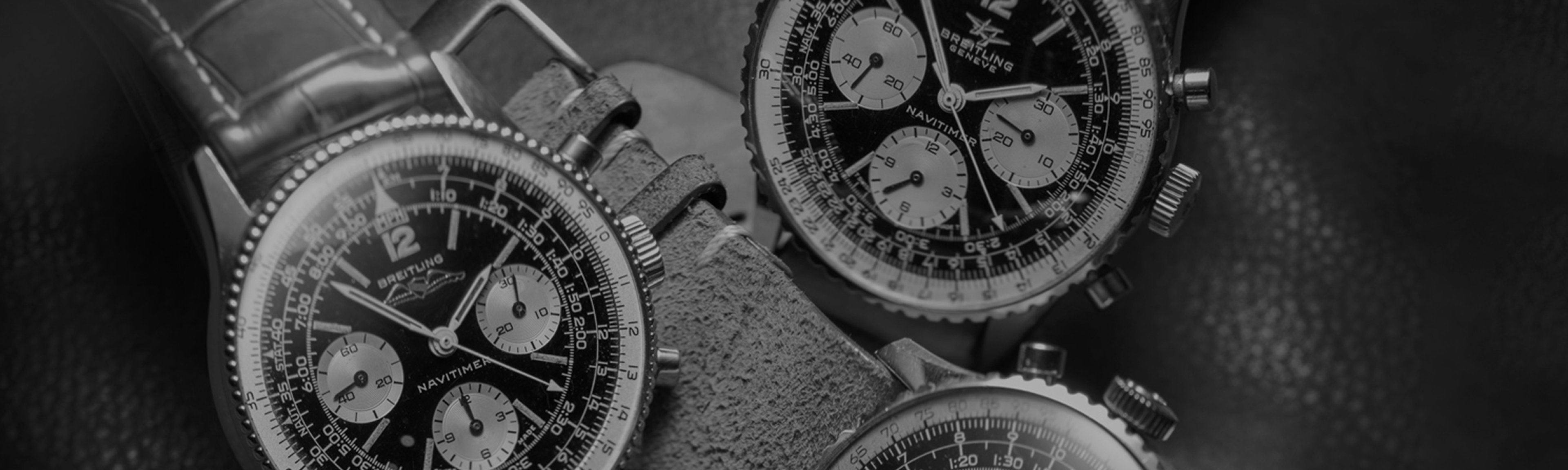 {generated} Three vintage Breitling Navitimer watches shown in a detailed close-up highlighting their black dials and classic chronograph design