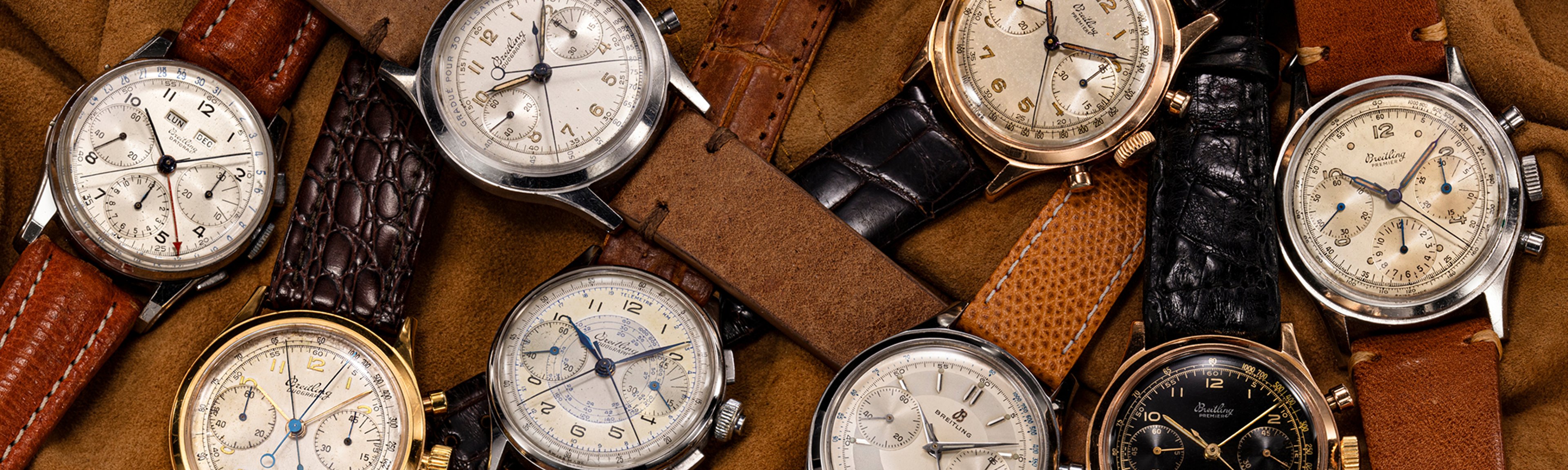{generated} Vintage Breitling Premier chronographs arranged on soft tan fabric, displaying varied dials and leather straps