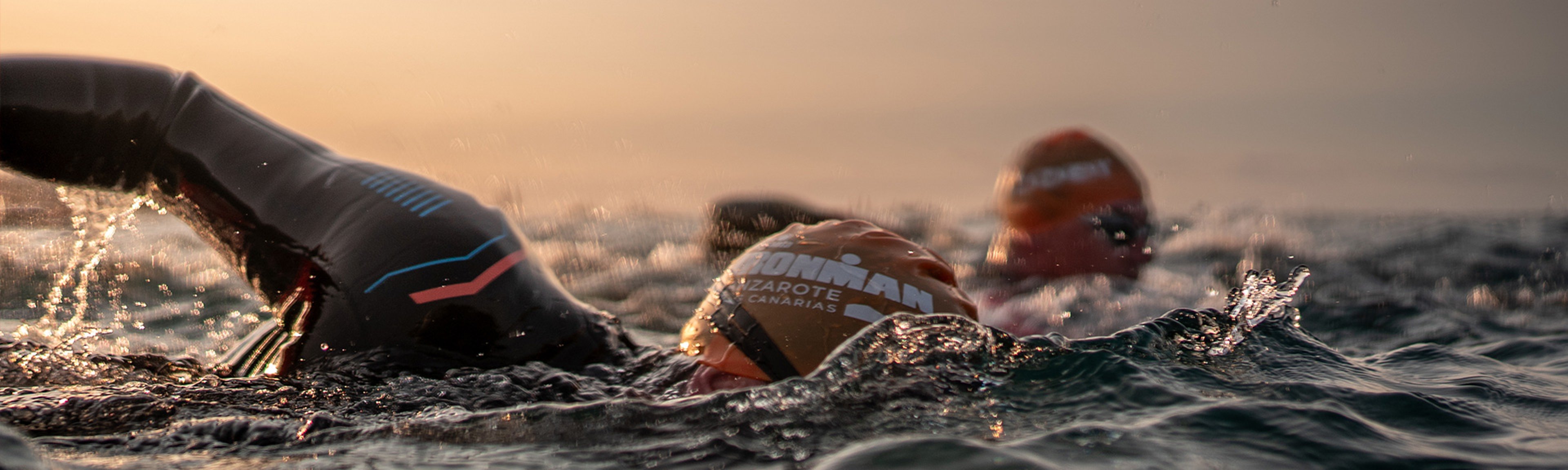 Two Ironman athletes, symbolising the partnership between Breitling and Ironman, jump into the water.