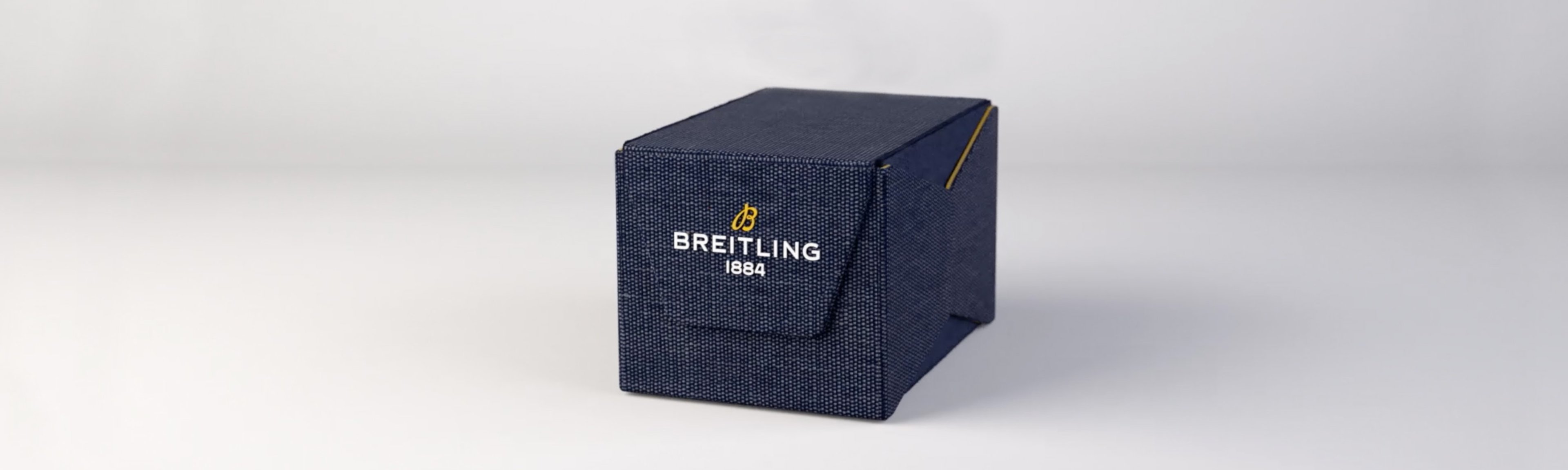 {generated} Une boîte texturée bleu marine avec le logo Breitling, mettant en valeur l’emballage raffiné de la marque sur un fond épuré.