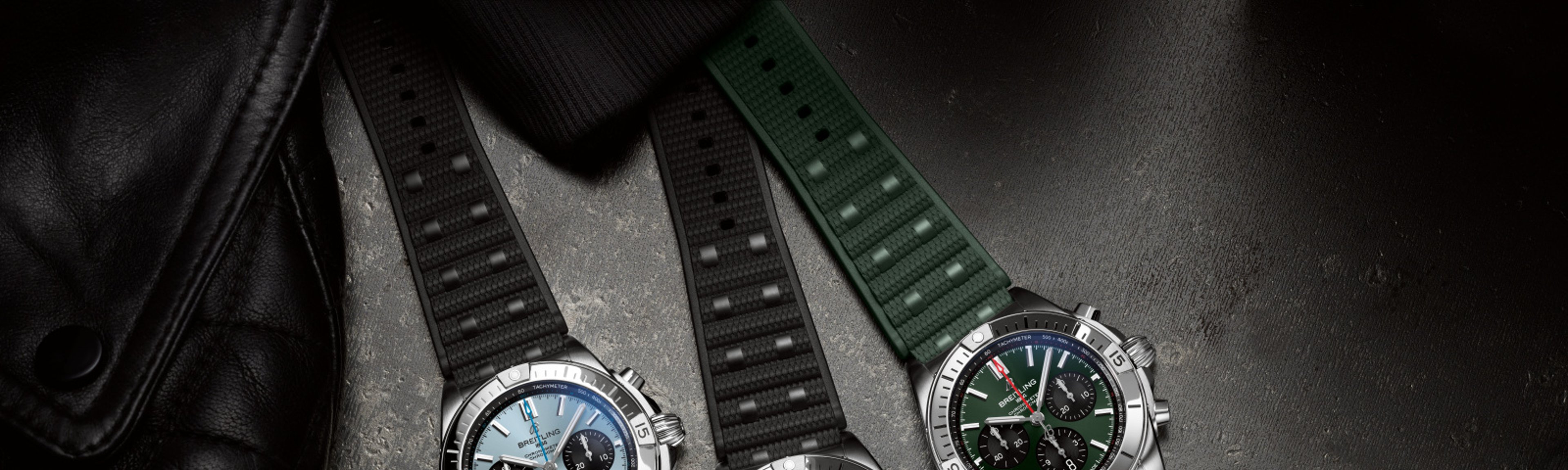 {generated} Breitling Chronomat new variants showcased with blue, bronze, and green dials on textured straps against dark surfaces