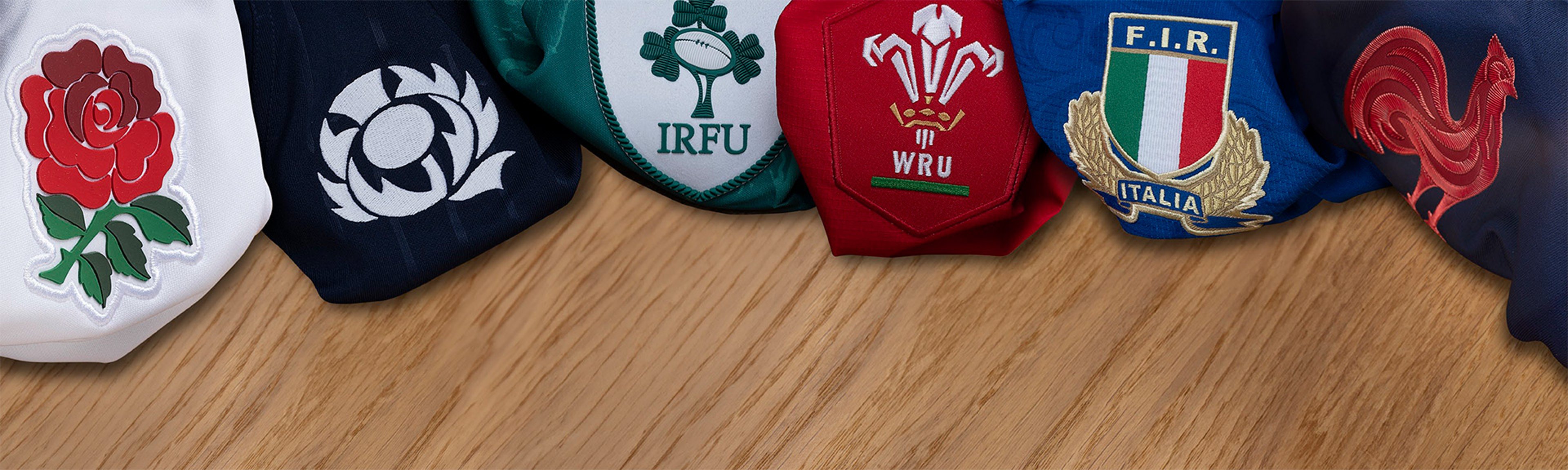 {generated} Rugby union team crests from the Six Nations displayed on colourful fabric folds against a wooden surface