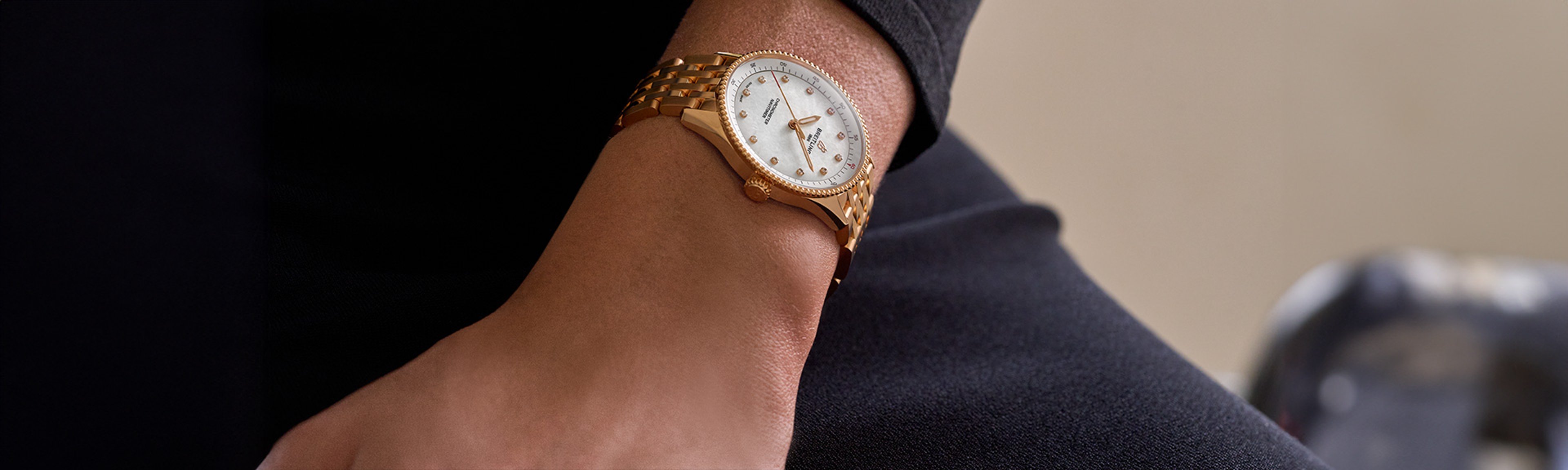 {generated} 女性の手首に白い文字盤とダイヤモンドインデックスを備えたゴールドのBreitlingウォッチが輝く上品なブティック空間。