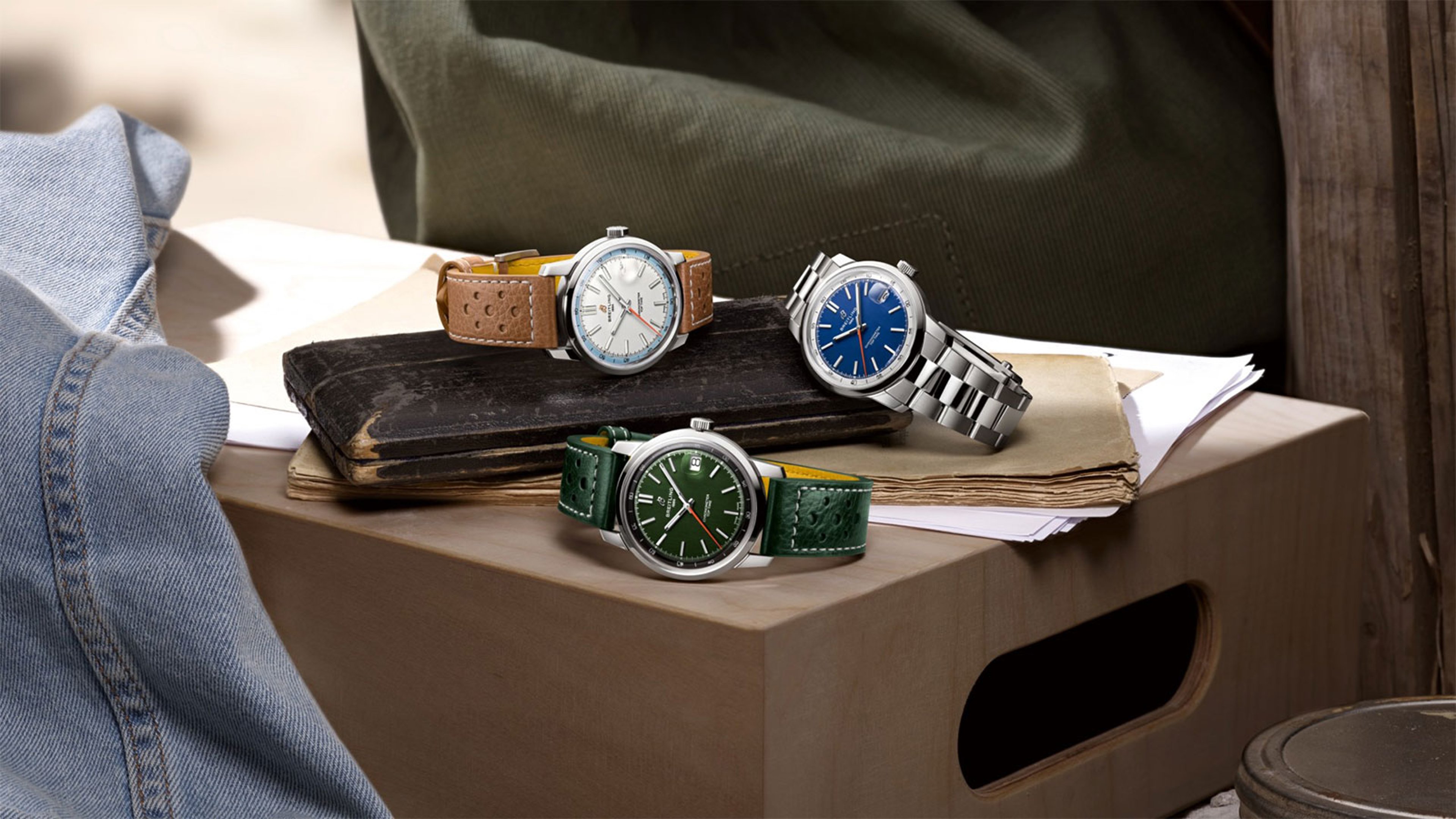 {generated} グリーン、ブルー、シルバーのBreitling Top Time B31がヴィンテージ本に置かれた落ち着いたスタジオ構成のシーン