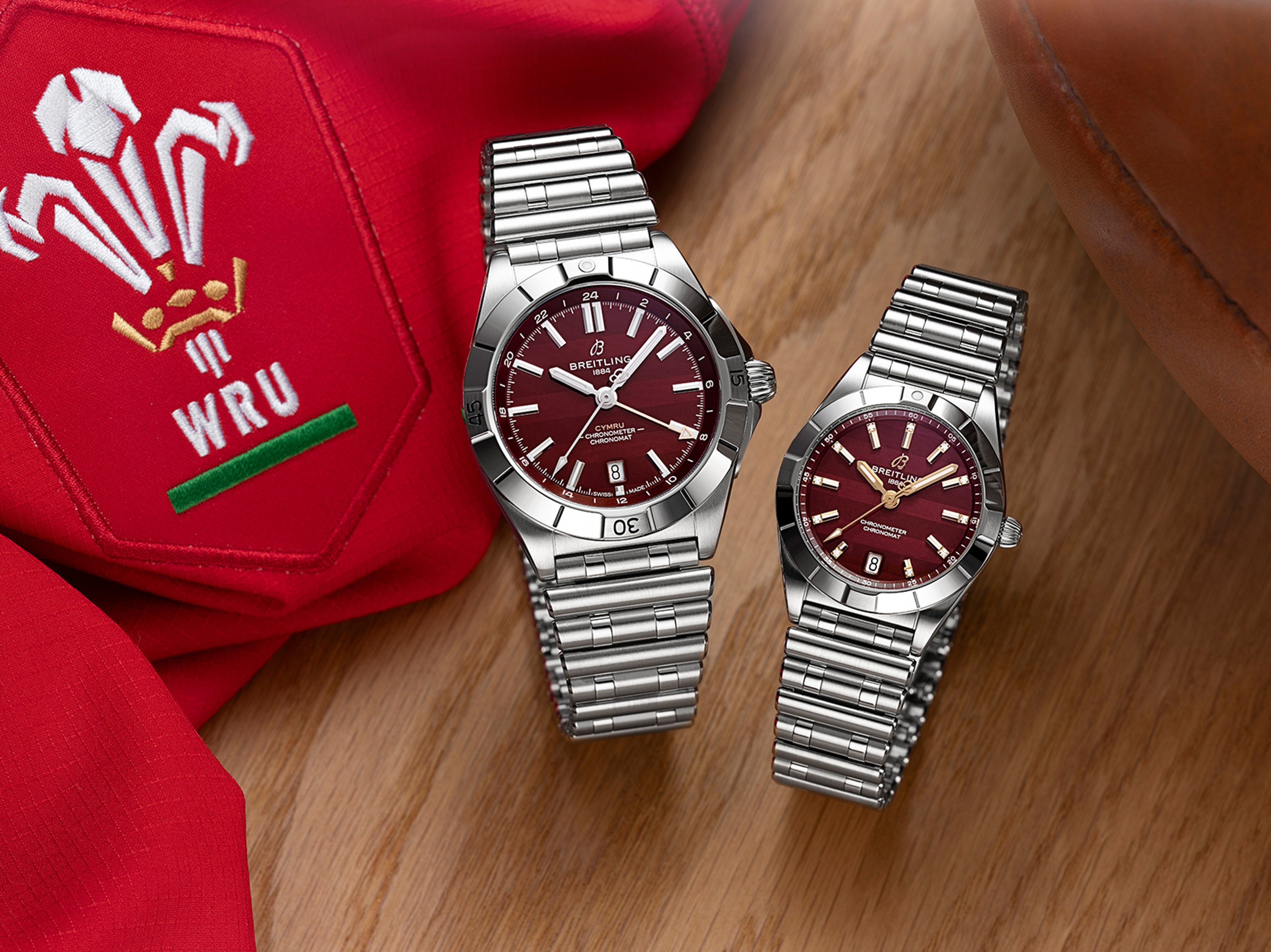{generated} Breitling Chronomat watches with red dials placed beside Welsh rugby kit, celebrating the Wales Six Nations link.