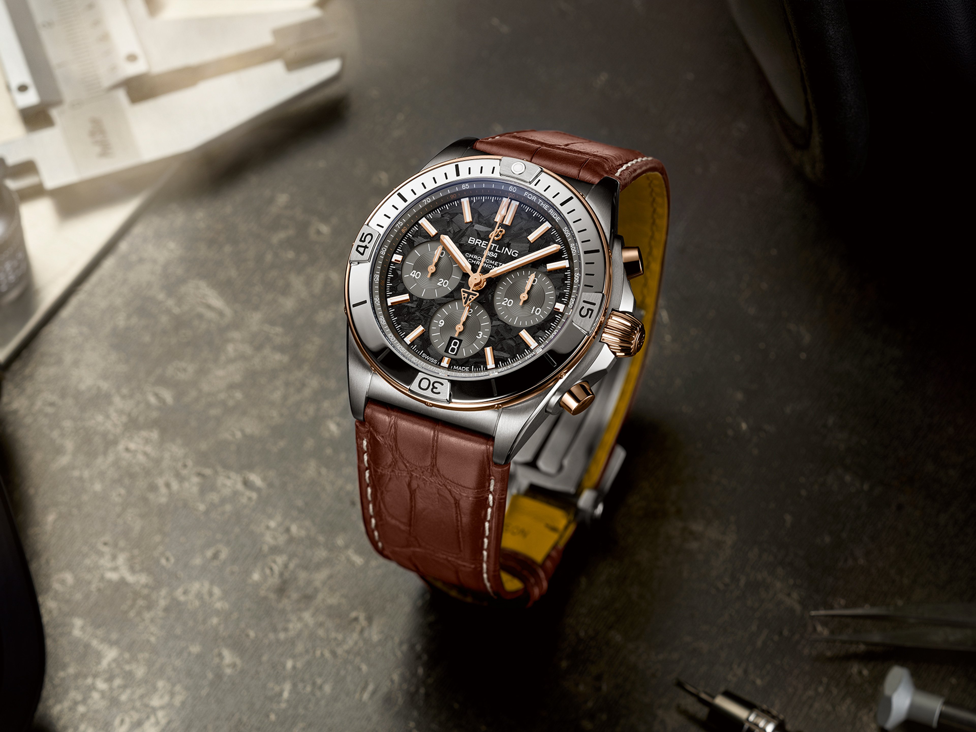 {generated} Breitling Chronomat model shown on a textured workbench, featuring its brown leather strap and refined polished steel case.