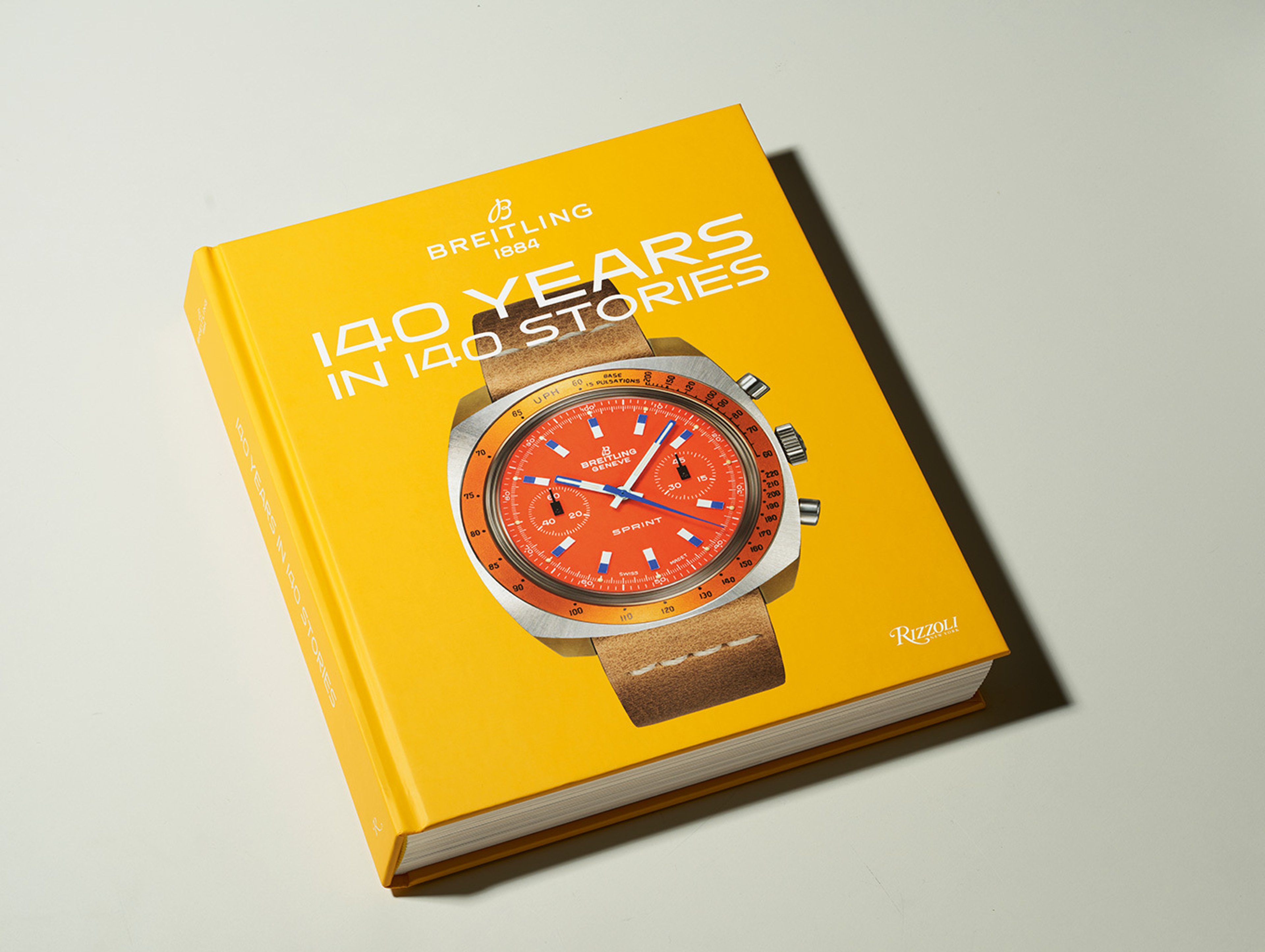 {generated} Bright yellow Breitling commemorative book featuring a vivid watch illustration celebrating the brand’s 140-year legacy