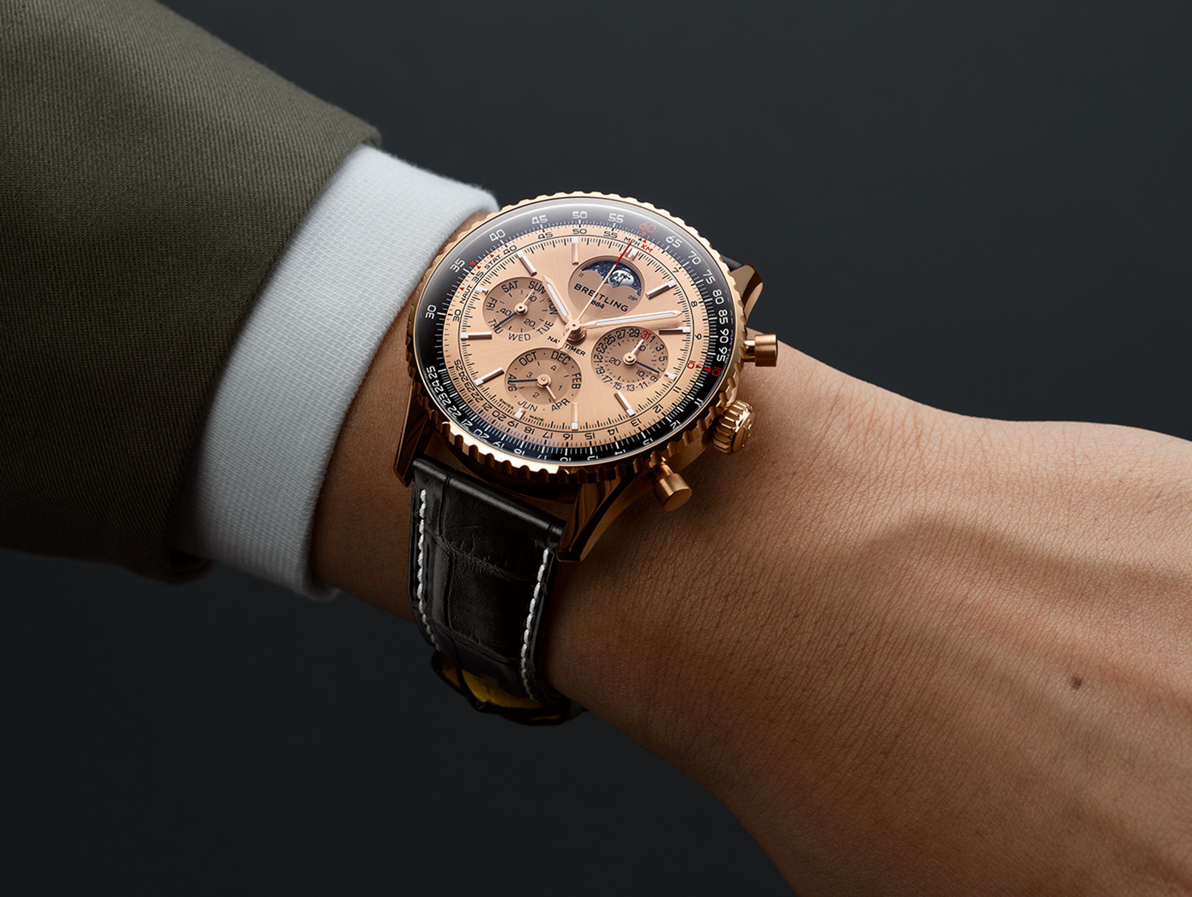 {generated} 腕上佩戴的Breitling Navitimer B19 Chronograph 43 Perpetual Calendar搭配玫瑰金錶殼與黑色皮錶帶