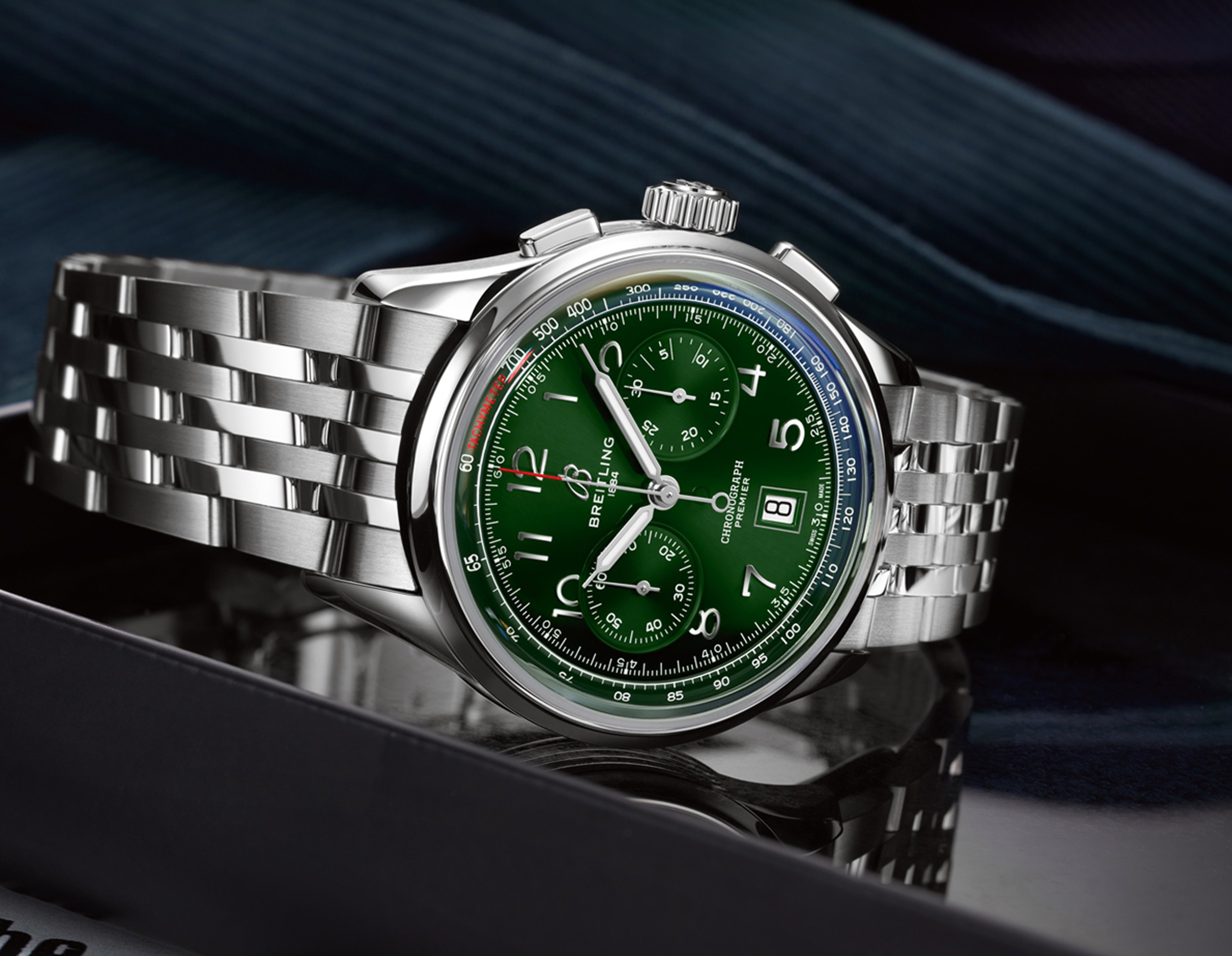 {generated} Breitling Premier watch with a green chronograph dial and polished steel bracelet displayed against a refined dark backdrop