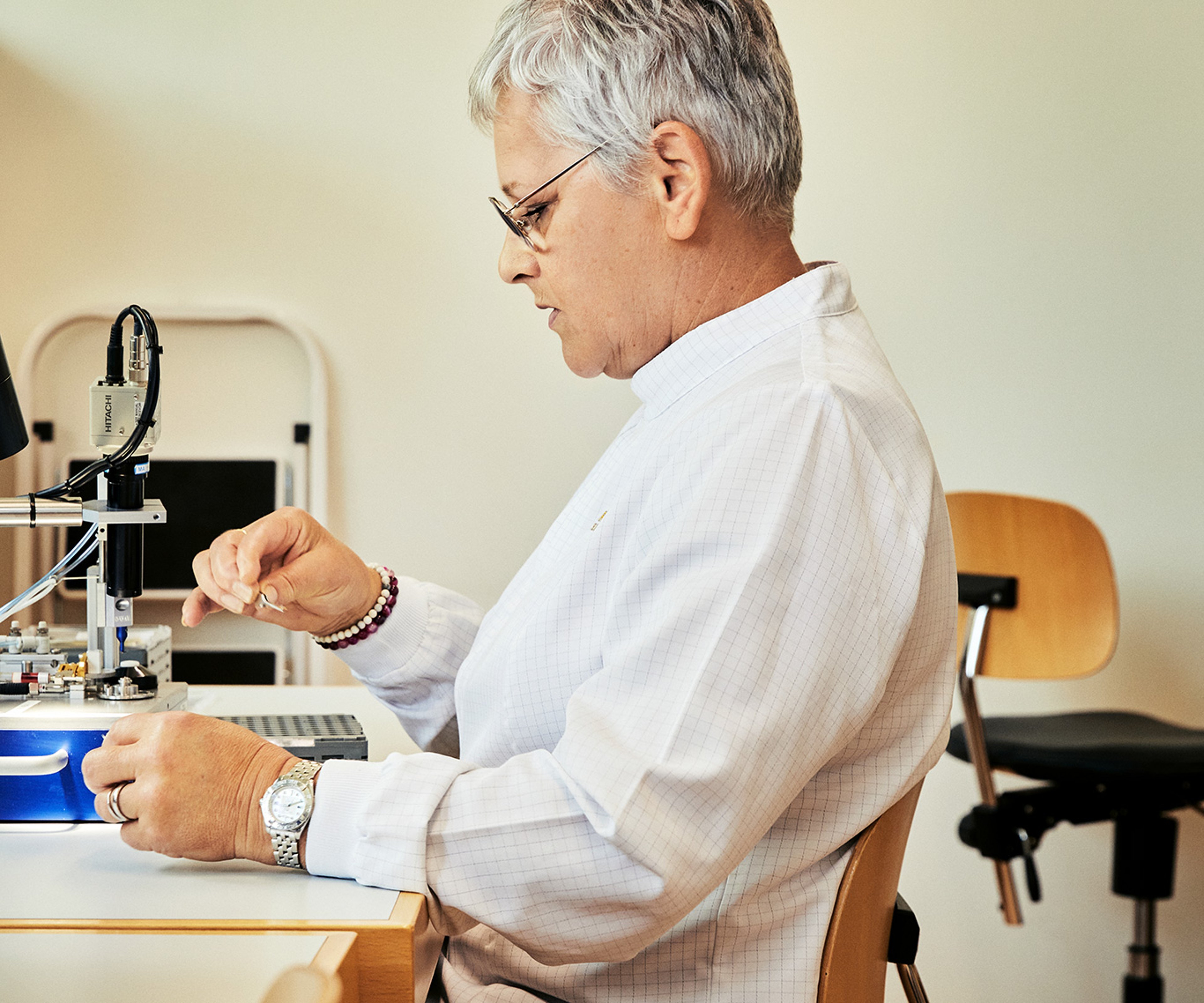 {generated} Un technicien utilise des outils de précision en portant une montre Breitling qui souligne l’engagement de gouvernance de la marque.