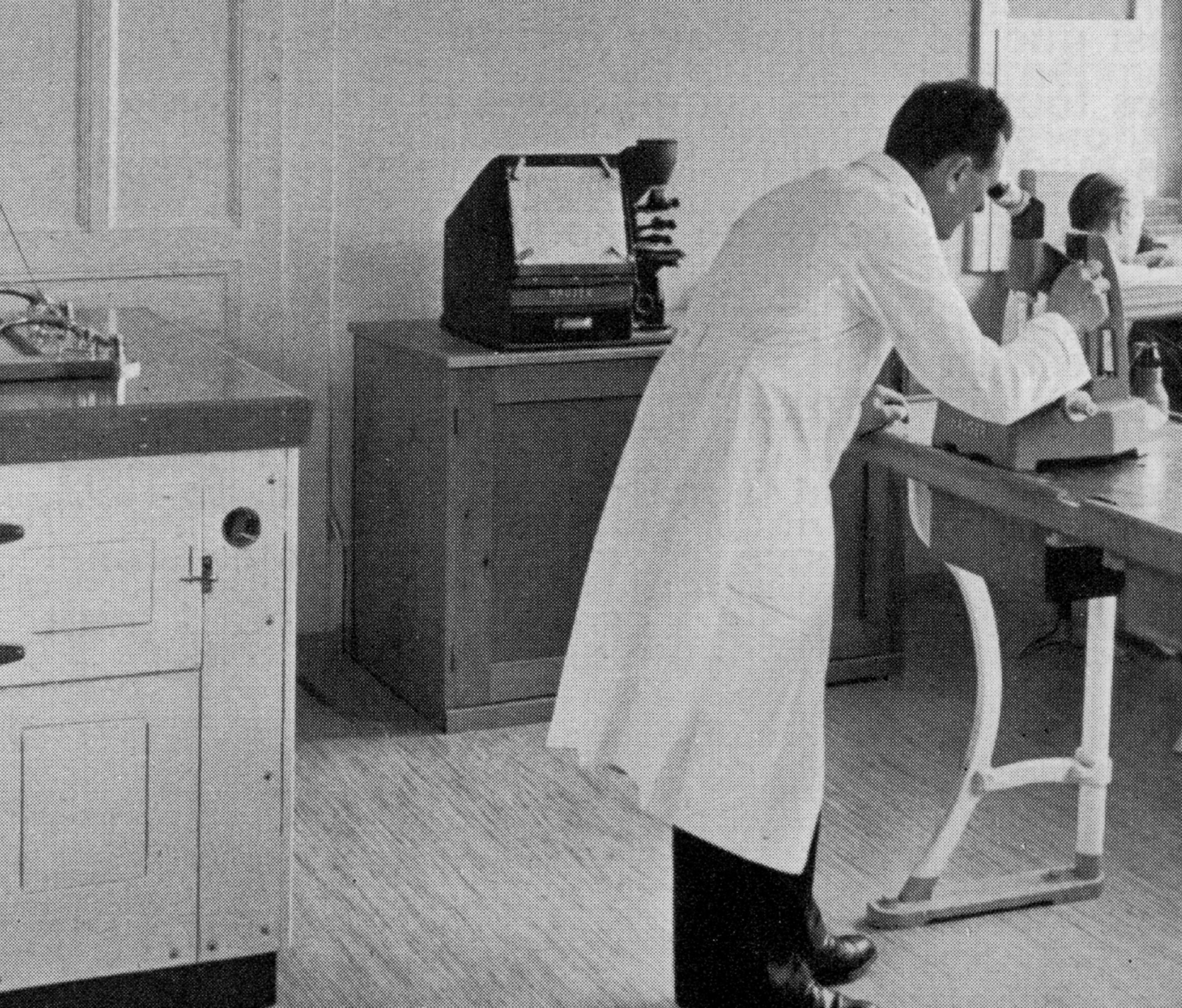 {generated} A technician in a lab coat studies precision equipment at a workbench, reflecting careful craftsmanship in a calm workshop
