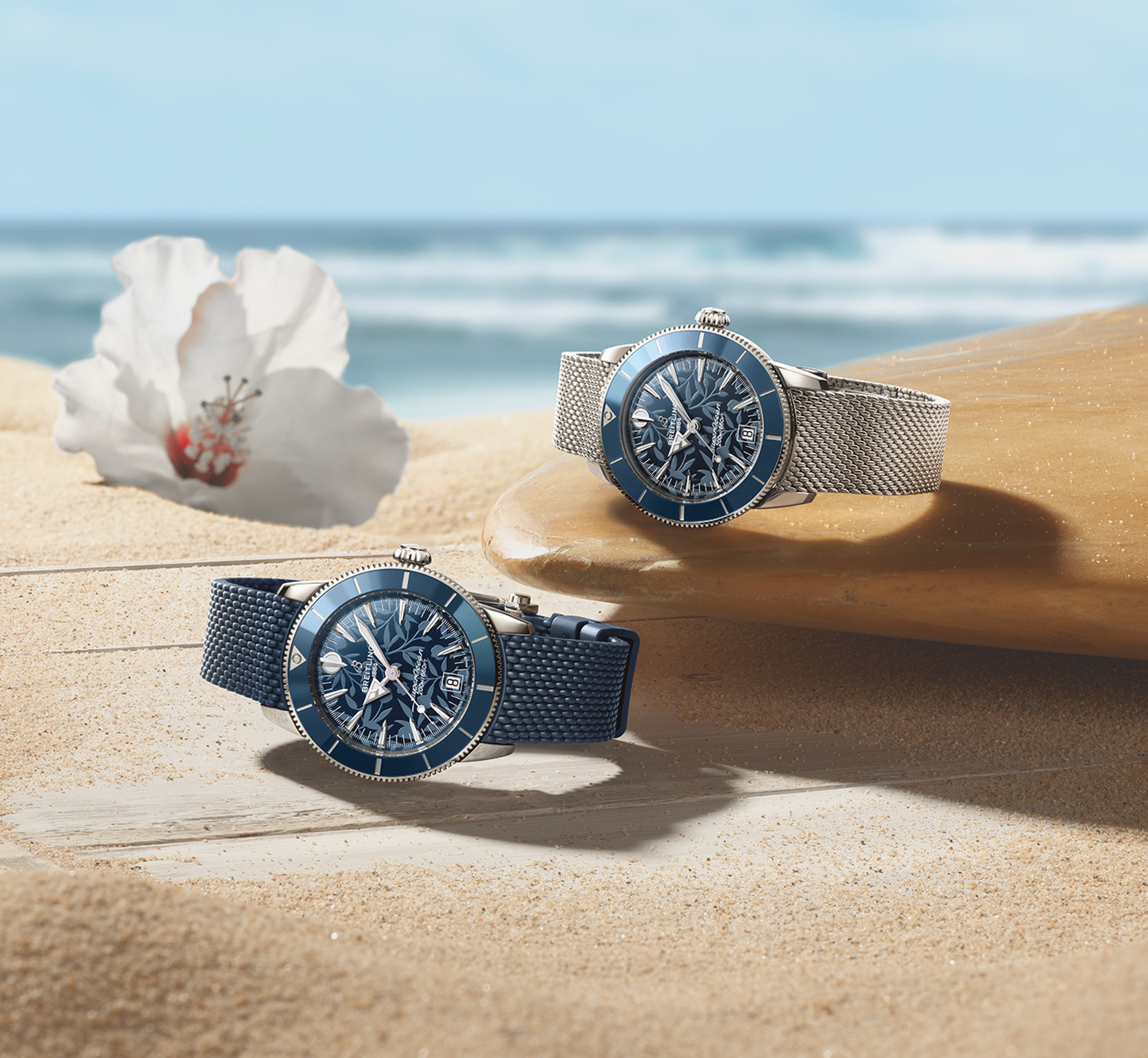 {generated} Breitling Superocean Heritage Kelly Slater watches with blue dials set on sandy beach beside a sunlit surfboard
