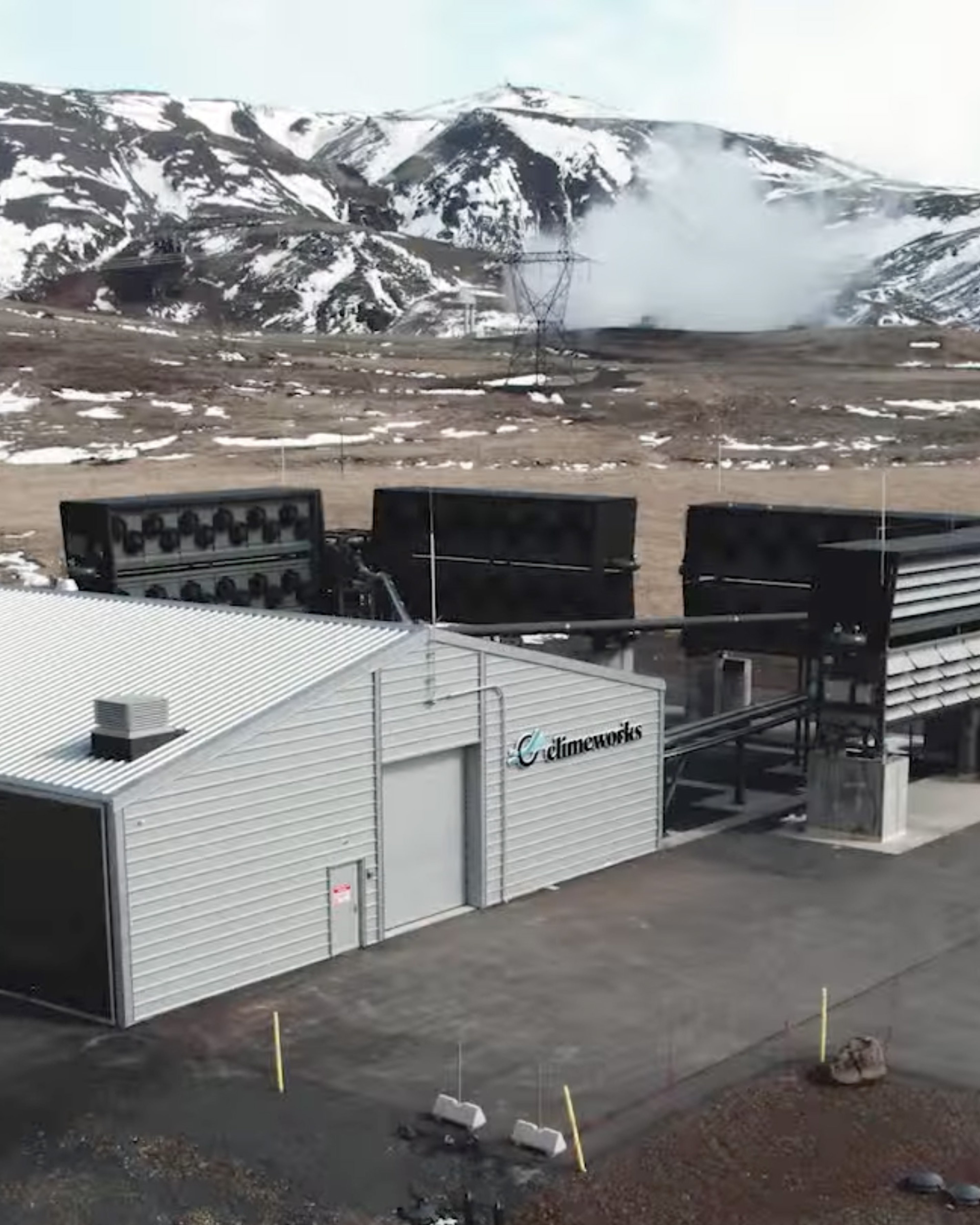 {generated} Site ClimeWorks devant des montagnes enneigées, doté d’unités industrielles de capture d’air intégrées au paysage rocailleux.