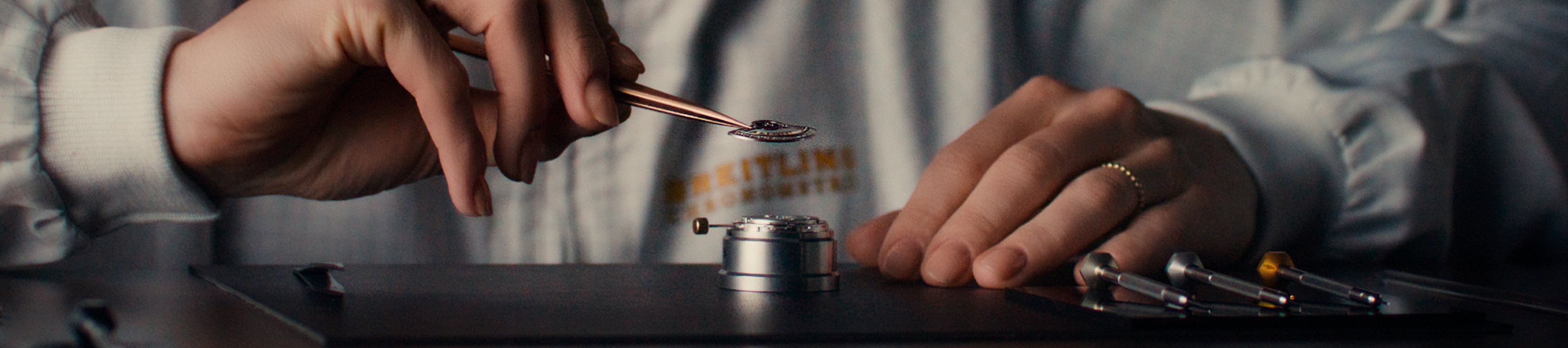 {generated} A watchmaker in a Breitling coat carefully adjusts a movement with precision tools, highlighting meticulous service work