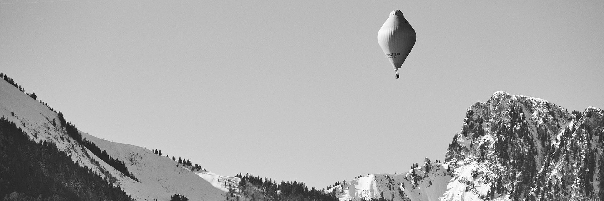 a blimp flying over snowy mountains