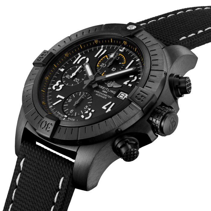 Bold, extremely robust and shock resistant, the Avenger Chronograph 45 Night Mission combines precision with a powerful design in a lightweight case. As a true Breitling Avenger, it can be used wearing gloves and offers unrivalled safety and reliability to any airborne adventurer. The Night Mission interpretation of the Avenger Chronograph 45 features a sturdy 45mm DLC-coated titanium case, black or khaki dial and a matching black or khaki military leather strap that fits either a DLC-coated stainless-steel pin buckle or folding clasp. Its specific Arabic numerals recall the stenciled numbers used on the decks of aircraft carriers. Thanks to its rugged bezel and its special grip-pattern on the crown & chronograph pushers, the Avenger Chronograph 45 Night Mission can be easily operated wearing gloves.