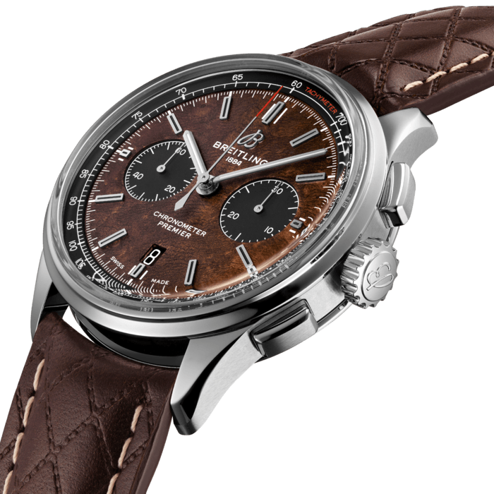 The Bentley Centenary Limited Edition in stainless-steel is presented on a brown quilted calfskin strap. It is also available with a stainless-steel bracelet. The watch has the unique brown burl elm dial, which is inspired by the wooden dashboard of the legendary 1929 “Blower” Bentley, the nickname given to the 4 ½ Litre Supercharged race cars driven by Sir Tim Birkin and the legendary Bentley Boys in the 1920s. The dial features contrasting black subdials and a white tachymeter scale on a black inner bezel around the dial, with a red tachymeter inscription. On the left side of the 42 mm steel case is a plate with an engraved “Bentley” inscription, which also owes its inspiration to the dashboard of the historic 1929 “Blower” Bentley. Inside the steel case is the Breitling Manufacture Caliber 01, a mechanical movement that has proven since years its performance and reliability. The movement is visible through a unique transparent caseback featuring a Bentley logo. The caseback is engraved with “1 OF 1000”.