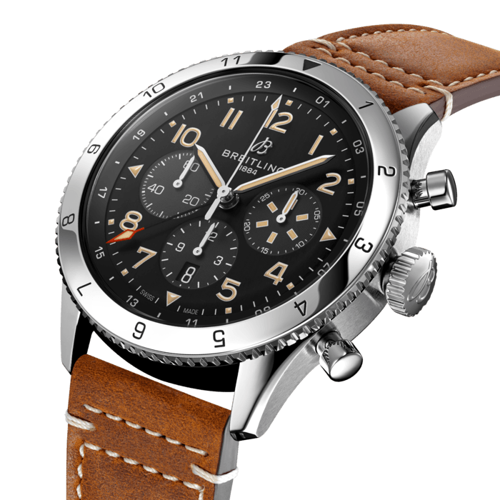 From brave first takeoffs to the birth of commercial air travel, Breitling’s history is inseparable from that of flight. In the 1930s, Breitling’s Huit Aviation department made its name inventing precision cockpit clocks. Two decades later, it introduced yet another novel flight instrument, this time in wearable form: the Ref. 765 AVI. That pioneering pilot’s watch provided the technical backdrop for today’s Super AVI, a collection inspired by the rugged spirit of famed early aircraft.
The Super AVI P-51 Mustang honors one of those legends. When the aircraft was built in a mere 120 days, even its developer North American Aviation, didn’t anticipate what a powerhouse it had on its hands. The P-51’s low-drag wings and engine-cooling system—considered experimental when the single-seat fighter first took off in 1940—gave it unprecedented speed and range. The addition of a Merlin engine, expanded the plane’s performance to high altitudes, making it the best all-purpose fighter of its time.
As a true pilot’s watch designed to withstand the rigors of a vintage cockpit, the Super AVI P-51 Mustang features large, highly legible Arabic numerals on the dial and bezel.
The oversized crown and knurled bezel on its sturdy 46mm case provide optimal grip, even in a pilot’s gloved hands. Top-stitched calfskin straps give a nod to the seams found on classic flight gear, while the optional stainless-steel bracelet provides an elegant alternative. Pilots and other travelers will appreciate the ability to track a second time zone using the 24-hour marking on the inner bezel and the red-tipped GMT hand. The engine of the Super AVI is the COSC-certified Breitling Manufacture Caliber B04 movement, which provides approximately 70-hours of power reserve.