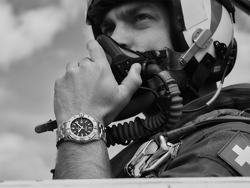 1936年，百年靈首次推出飛行員計時腕錶。百年靈與航空領域的淵源，就此揭開序幕。錶款配有黑色錶盤、醒目的夜光數字和旋轉錶圈，在黑暗和天空中皆能閃耀動人。